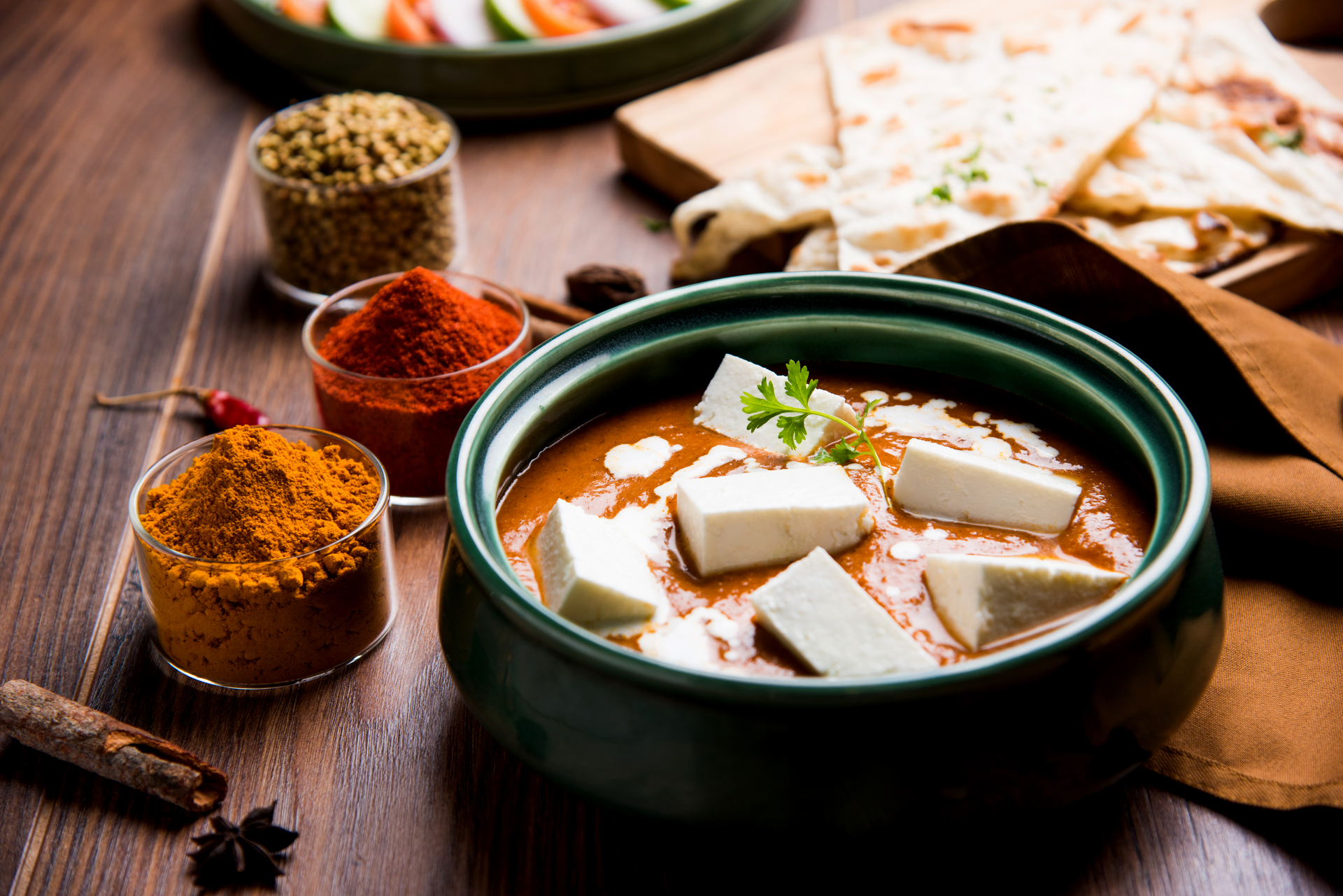 Overhead flat-lay of all ingredients for Creamy Indian Paneer Makhani laid out on a kitchen surface.