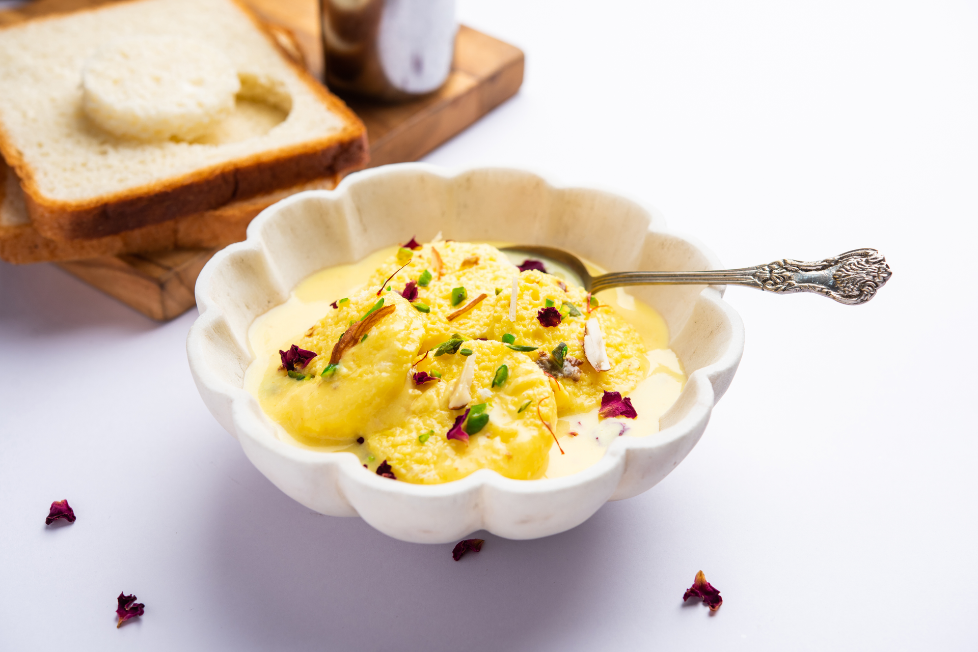 Overhead flat-lay of all ingredients for Creamy Indian Rasmalai with Saffron Syrup laid out on a kitchen surface.