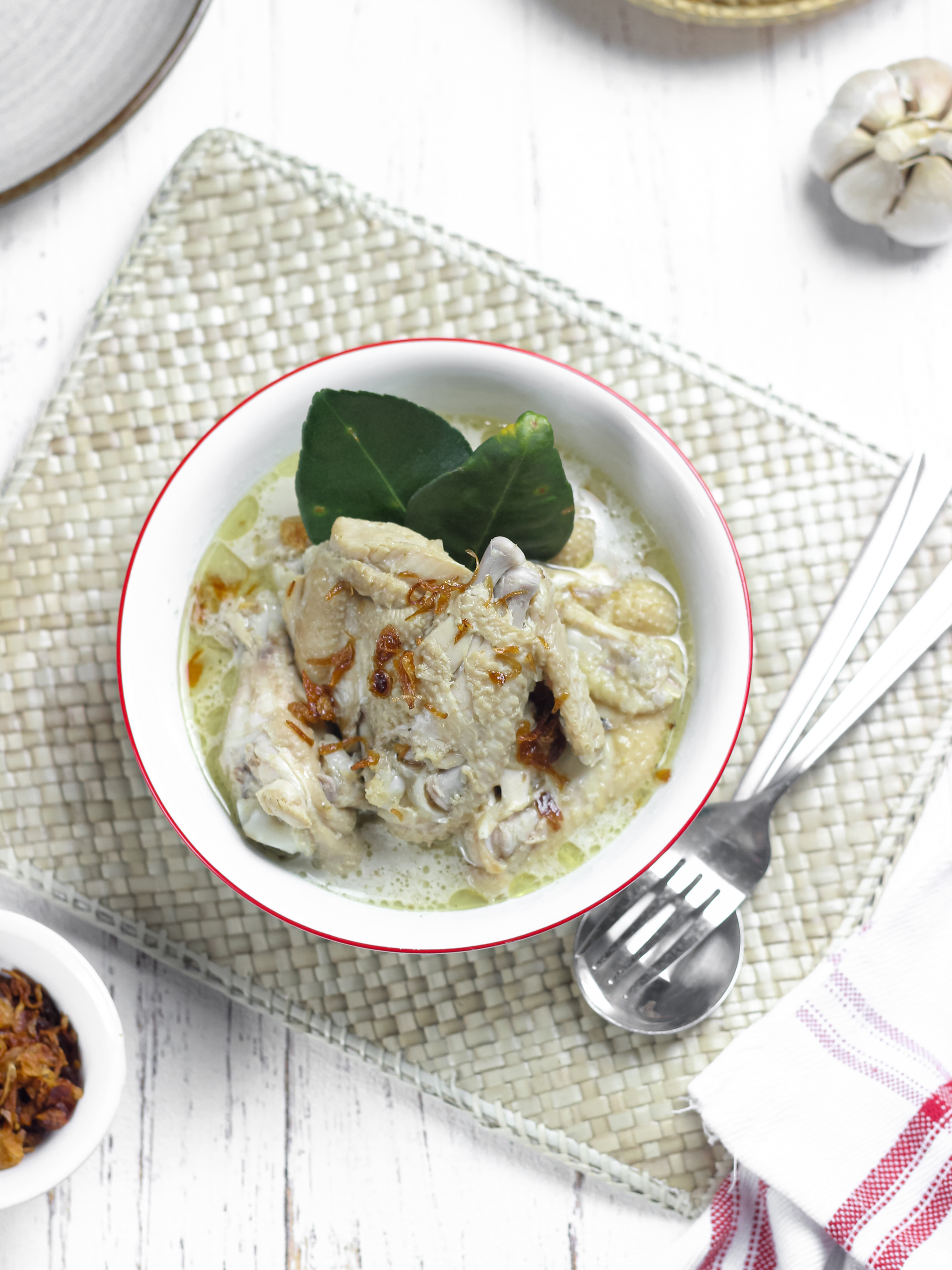 Overhead flat-lay of all ingredients for Creamy Malaysian Soto Ayam with Lemongrass and Coconut Milk laid out on a kitchen surface.
