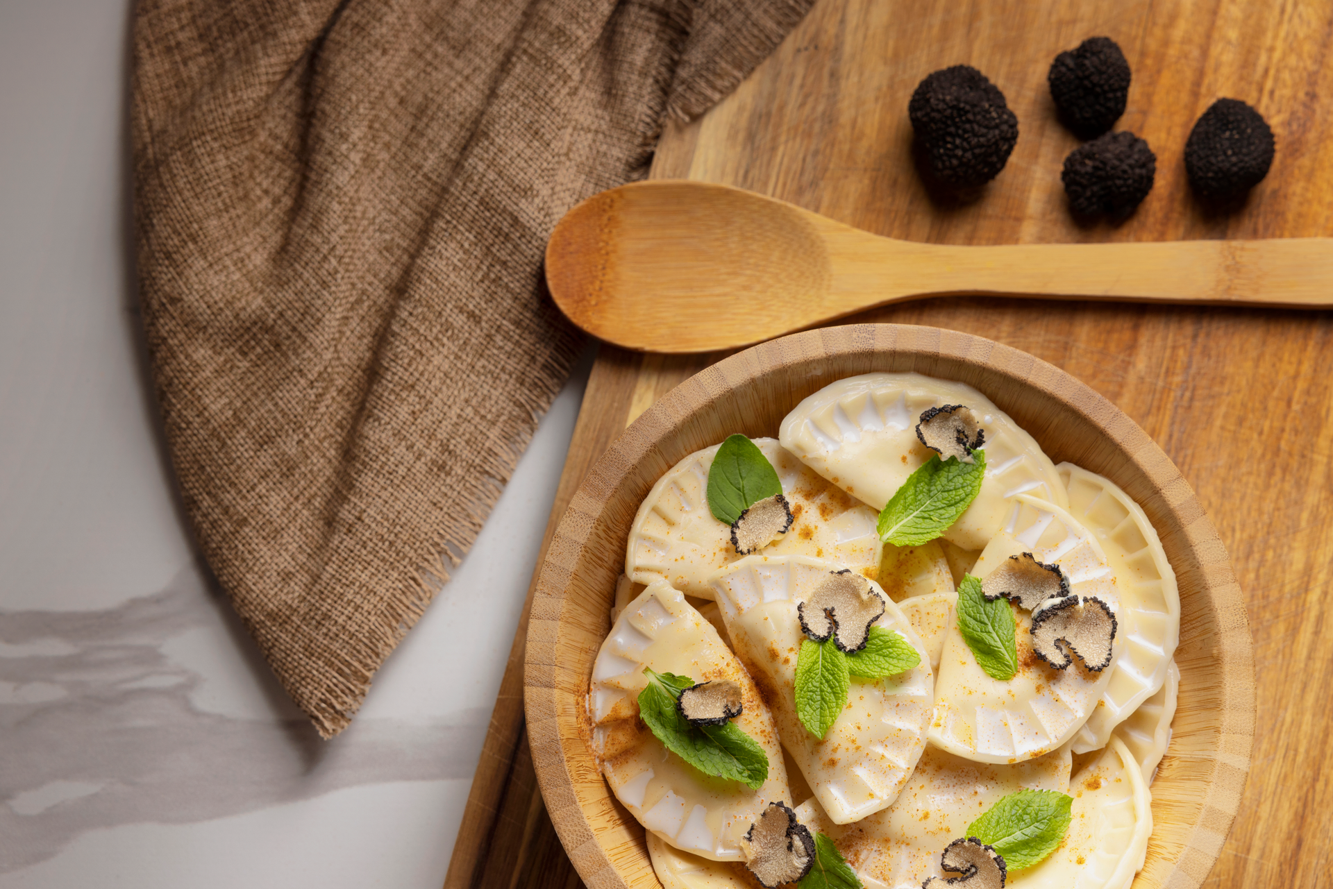 Overhead flat-lay of all ingredients for Creamy Polish Kolduny Dumplings with Wild Mushroom Sauce laid out on a kitchen surface.