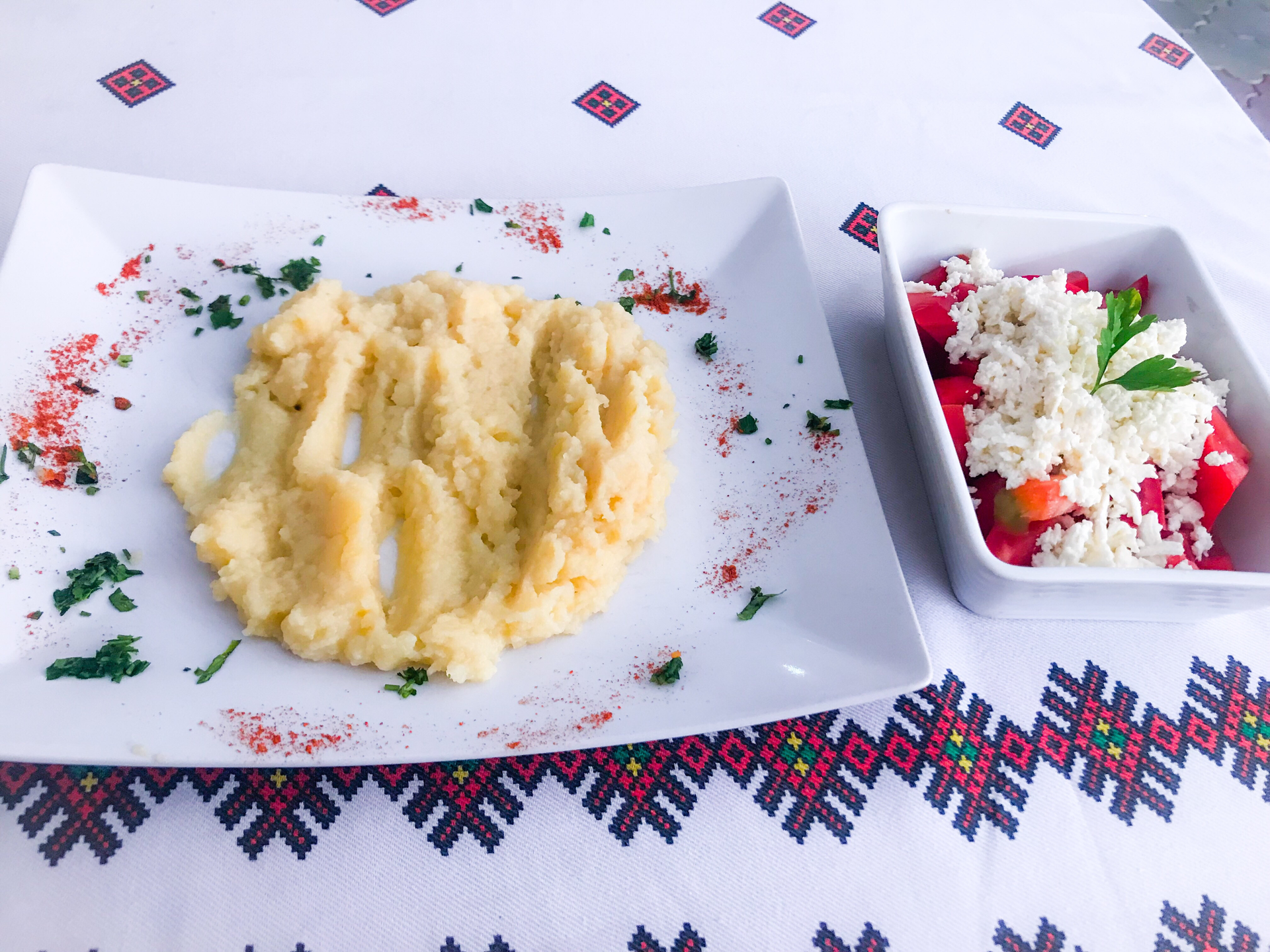 Overhead flat-lay of all ingredients for Creamy Romanian Mămăligă with Cheese and Sour Cream laid out on a kitchen surface.