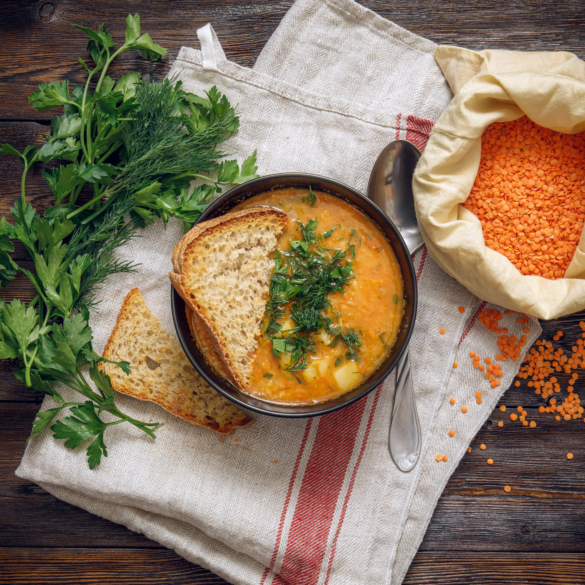Overhead flat-lay of all ingredients for Creamy Turkish Ezogelin Soup with Red Lentils and Bulgur laid out on a kitchen surface.