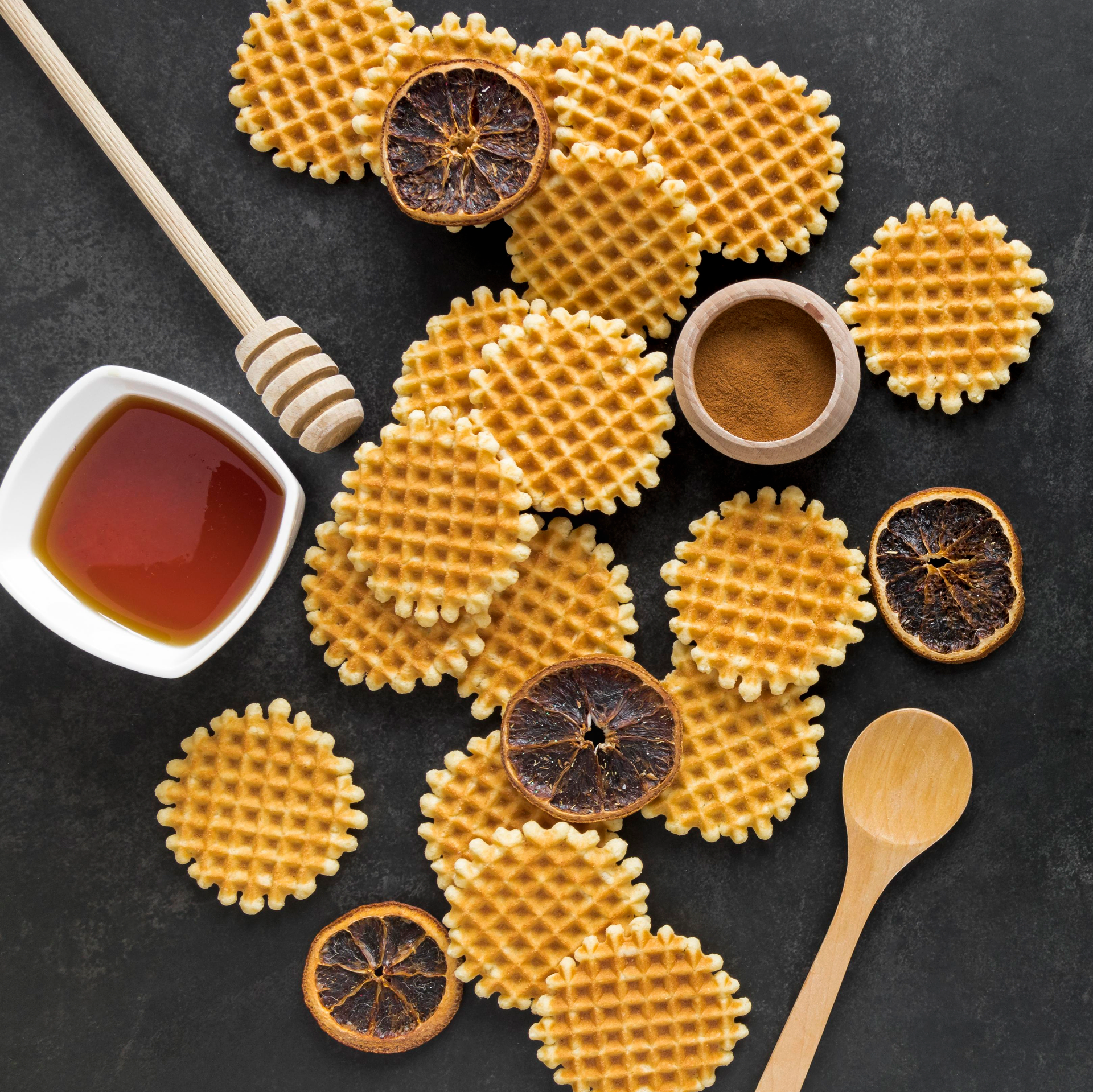 Overhead flat-lay of all ingredients for Crisp Dutch Stroopwafels with Caramel Drizzle laid out on a kitchen surface.
