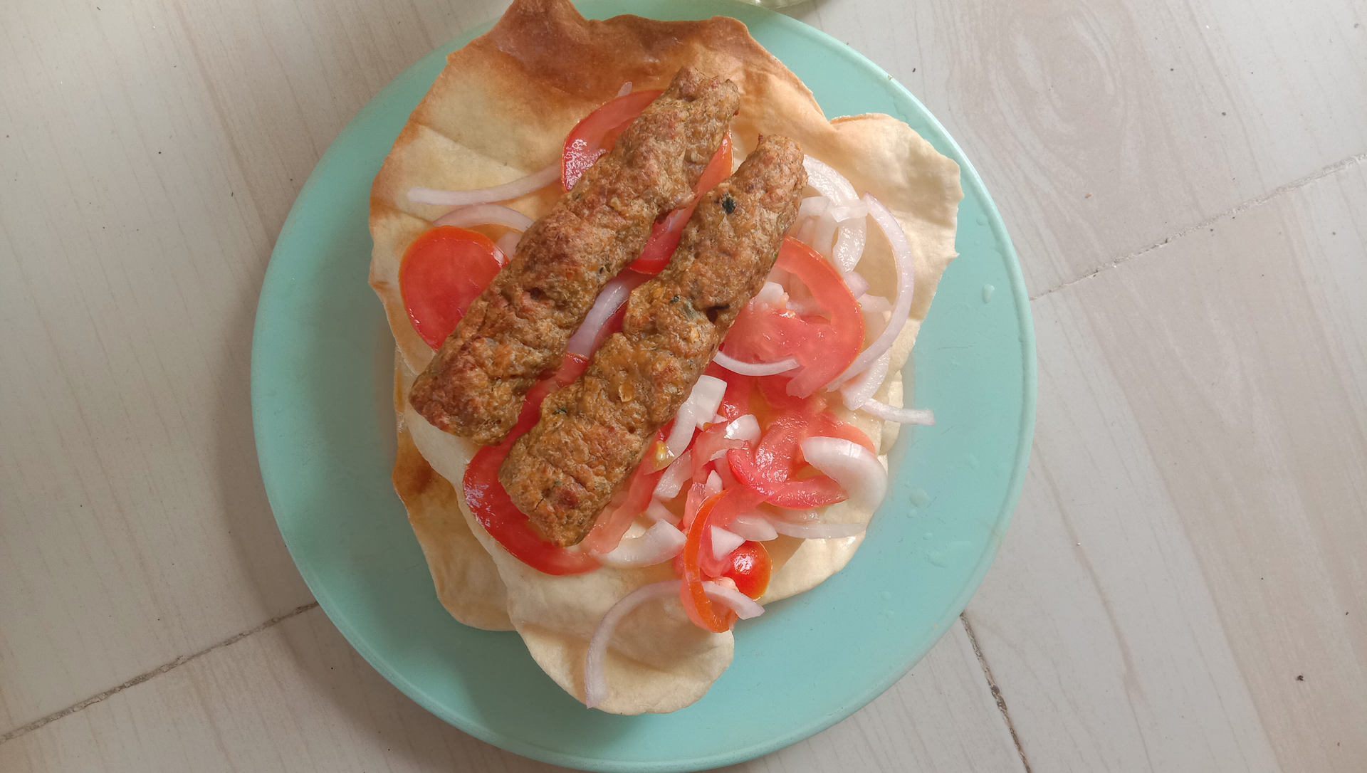 Overhead flat-lay of all ingredients for Croatian Ćevapi with Ajvar and Flatbread laid out on a kitchen surface.
