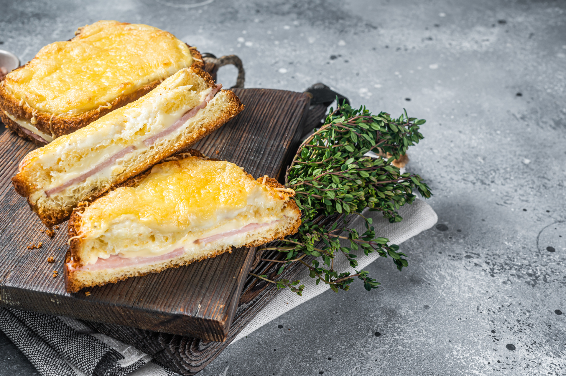 Overhead flat-lay of all ingredients for Croque Monsieur with Gruyere and Ham laid out on a kitchen surface.