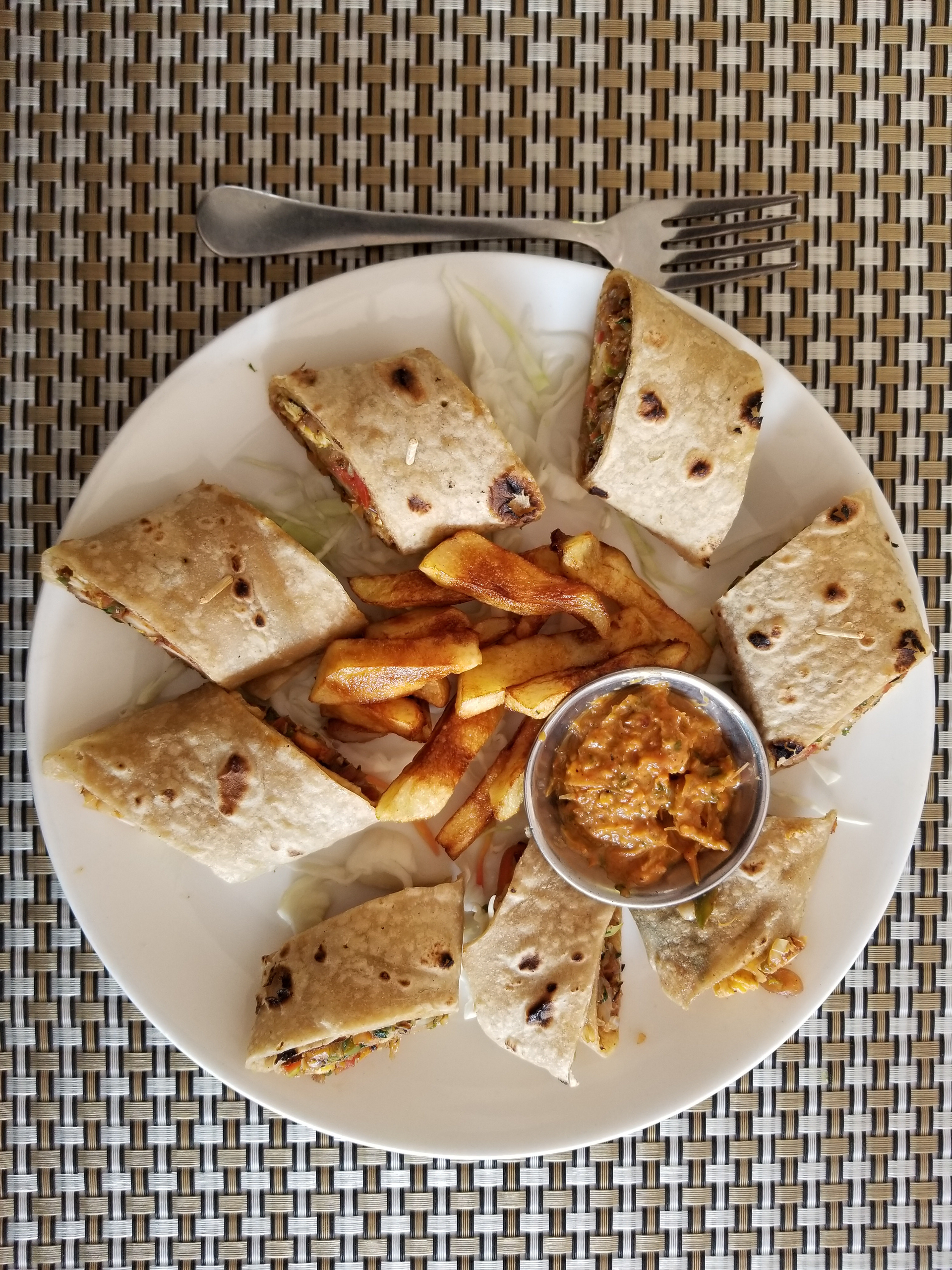 Overhead flat-lay of all ingredients for Curried Jamaican Ital Roti with Callaloo and Crunchy Nuts laid out on a kitchen surface.