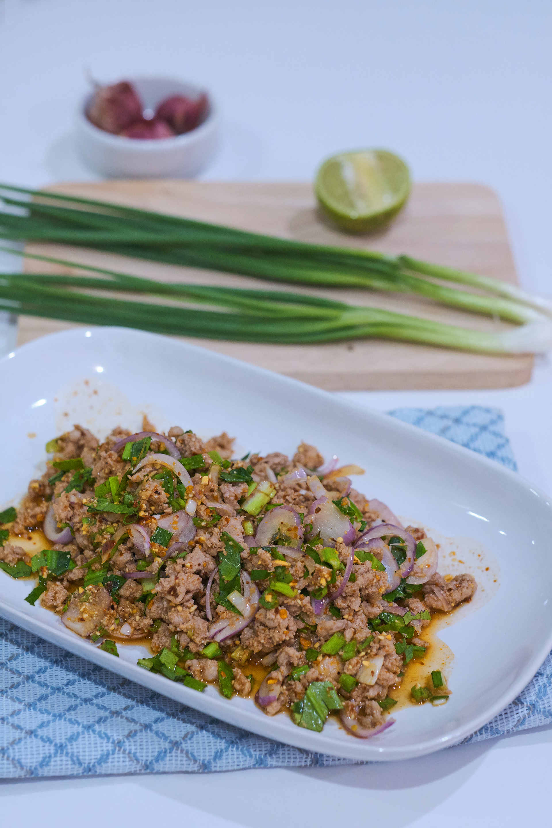 Overhead flat-lay of all ingredients for Delicious Laotian Larb with Ground Chicken and Lime laid out on a kitchen surface.