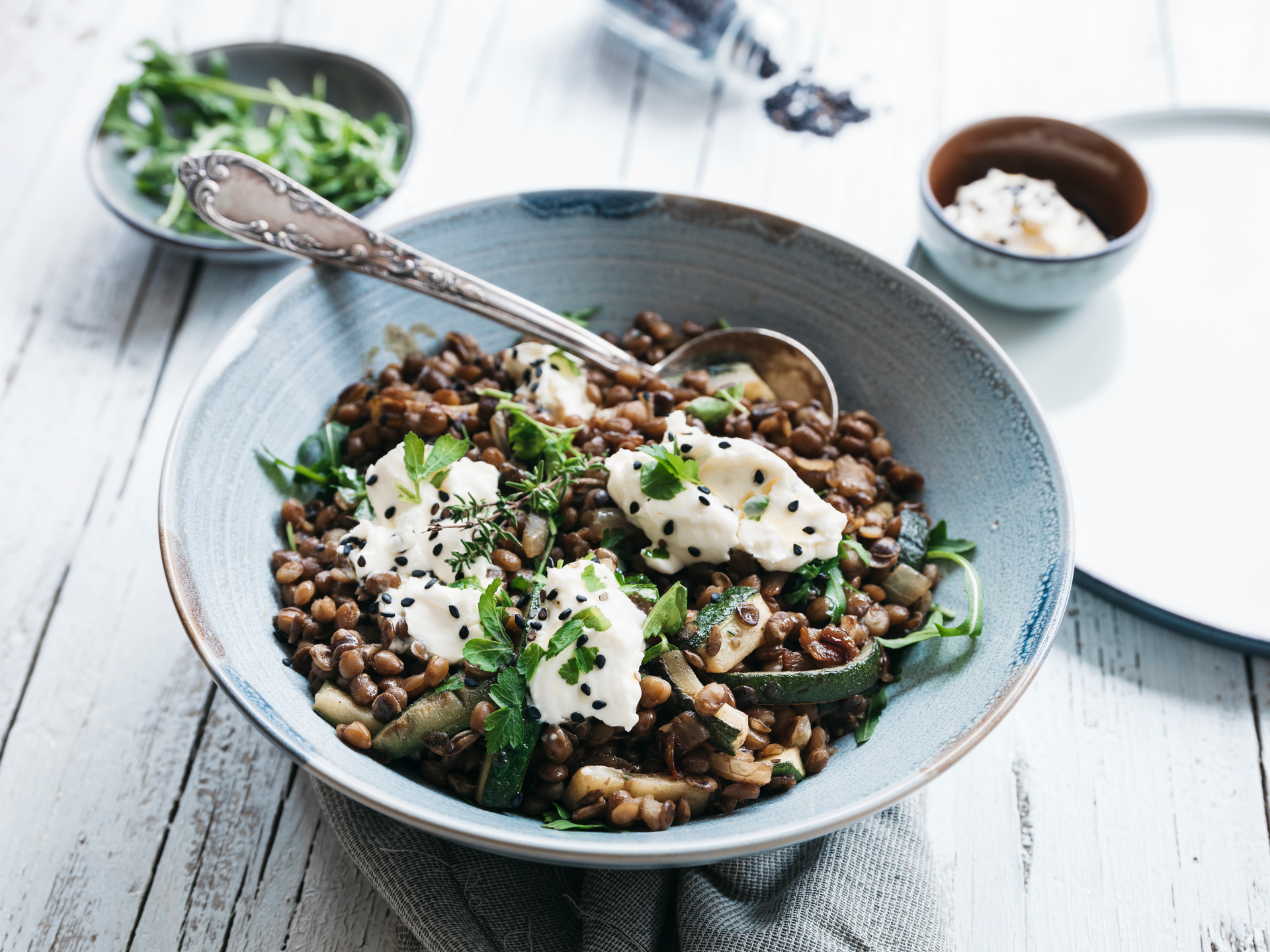 Overhead flat-lay of all ingredients for Earthy French Lentil Salad with Goat Cheese and Walnuts laid out on a kitchen surface.