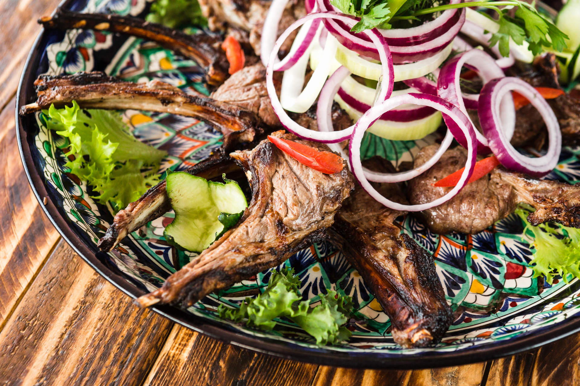 Overhead flat-lay of all ingredients for Ethiopian Mitmita-Spiced Lamb Chops with Injera Salad laid out on a kitchen surface.