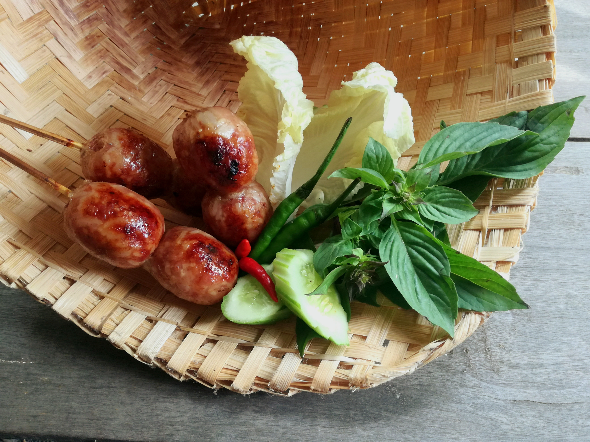 Overhead flat-lay of all ingredients for Exotic Balinese Urutan Sausage with Aromatic Spices laid out on a kitchen surface.