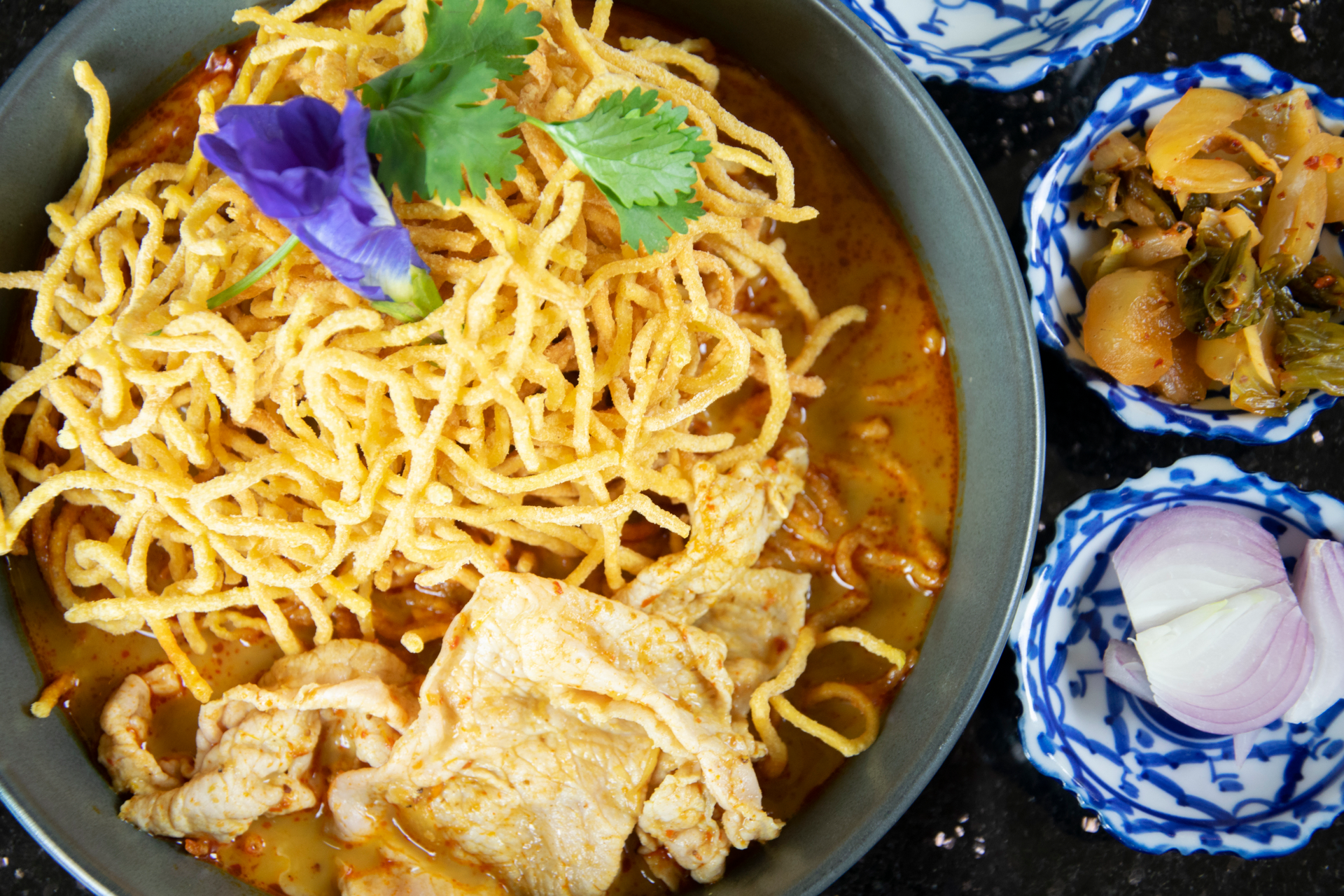 Overhead flat-lay of all ingredients for Exotic Burmese Mandalay Noodles with Coconut Curry laid out on a kitchen surface.