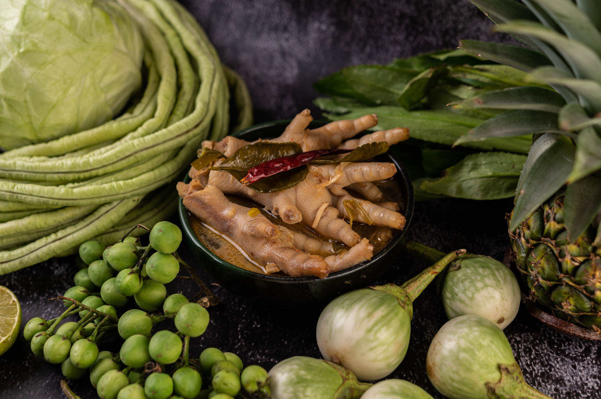 Overhead flat-lay of all ingredients for Exotic Laotian Lemongrass Tamarind Duck laid out on a kitchen surface.