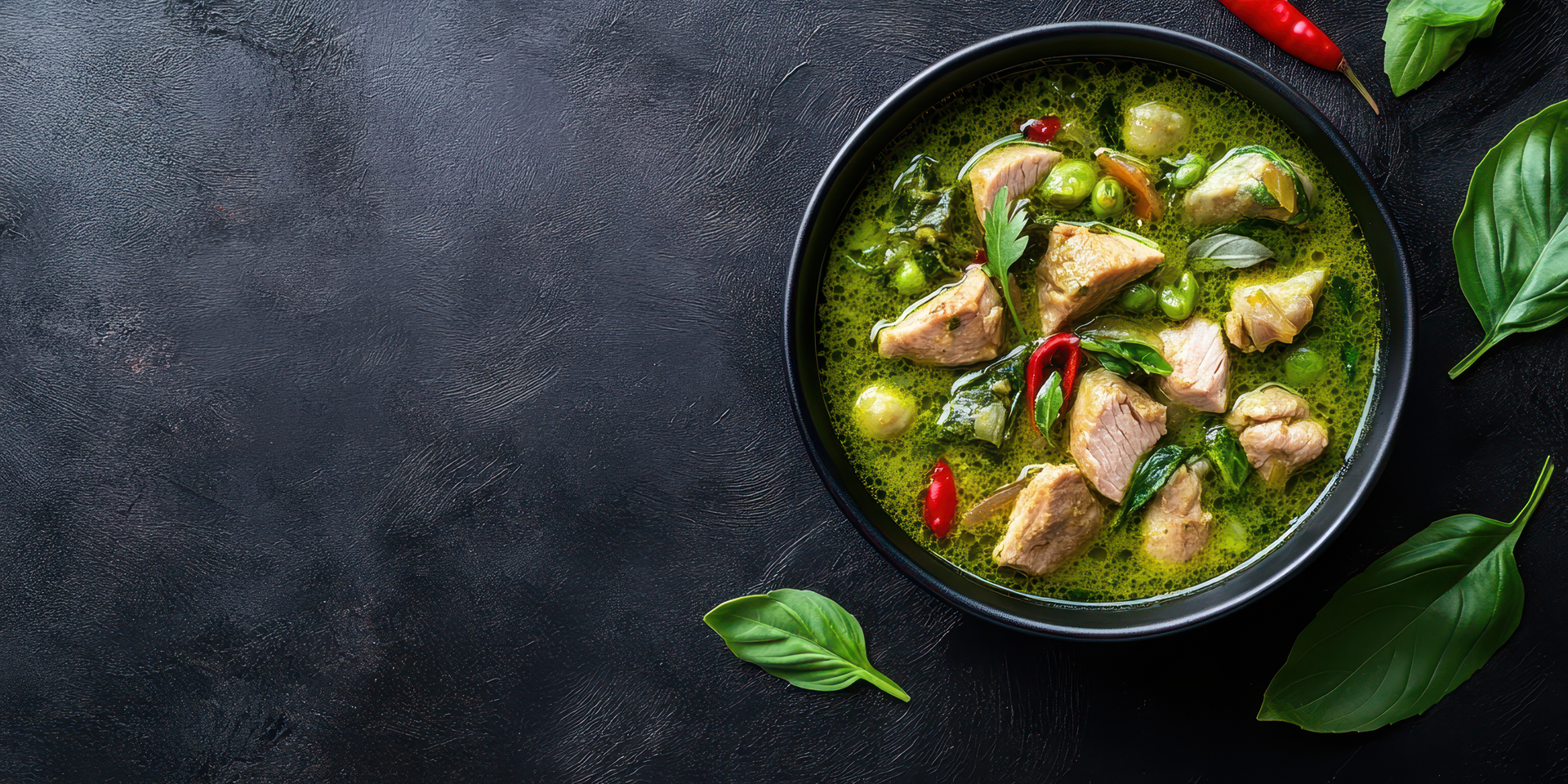 Overhead flat-lay of all ingredients for Exotic Thai Green Chicken Curry with Sweet Basil laid out on a kitchen surface.