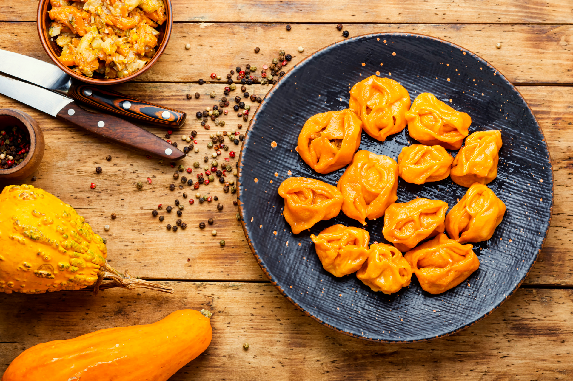 Overhead flat-lay of all ingredients for Exotic Turkish Manti with Spiced Pumpkin Filling laid out on a kitchen surface.