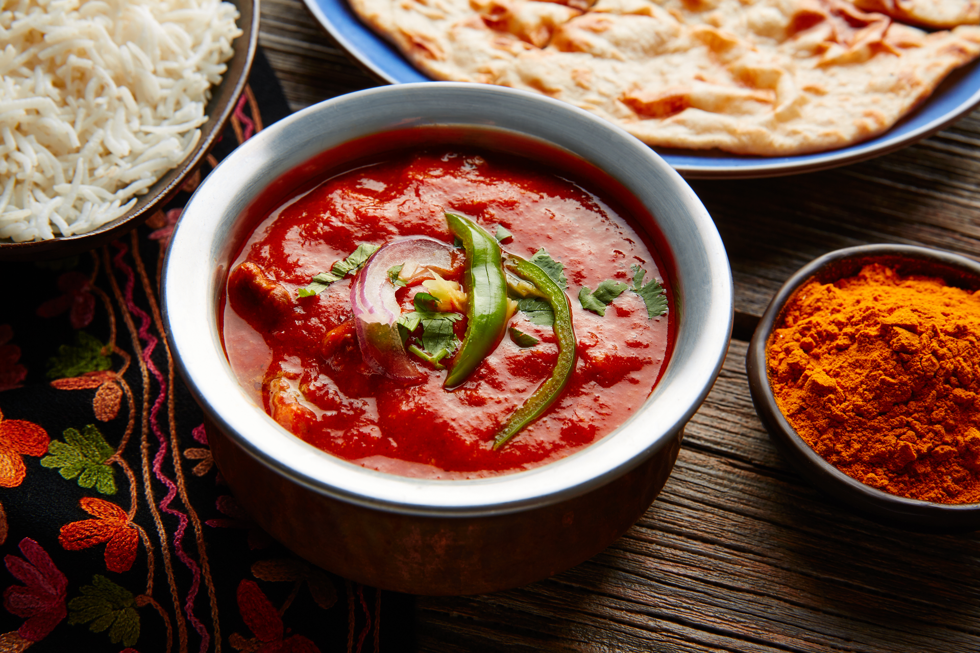 Overhead flat-lay of all ingredients for Fiery Indian Laal Maas laid out on a kitchen surface.