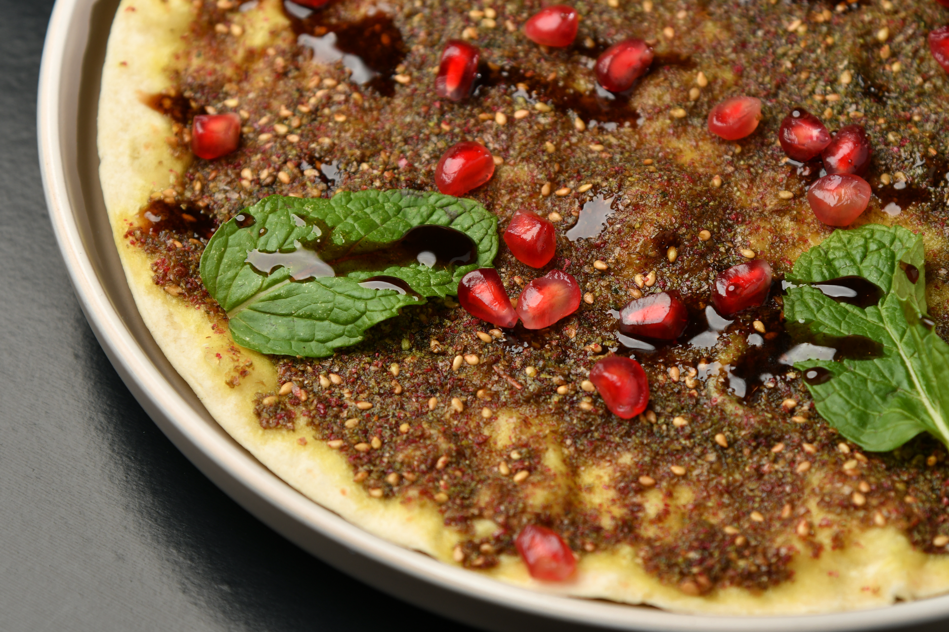 Overhead flat-lay of all ingredients for Flaky Lebanese Thyme Manakish with Sumac Onions laid out on a kitchen surface.
