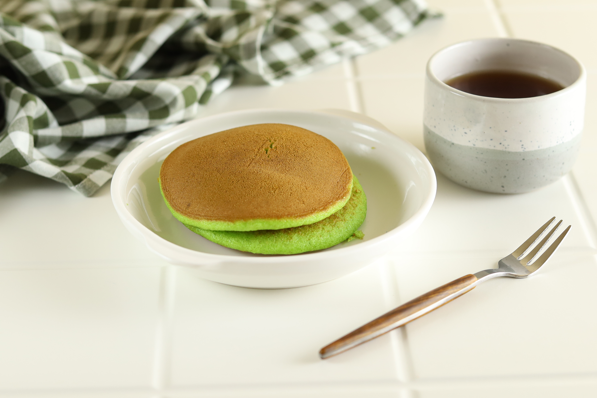 Overhead flat-lay of all ingredients for Fluffy Japanese Matcha Pancakes with Red Bean Cream laid out on a kitchen surface.