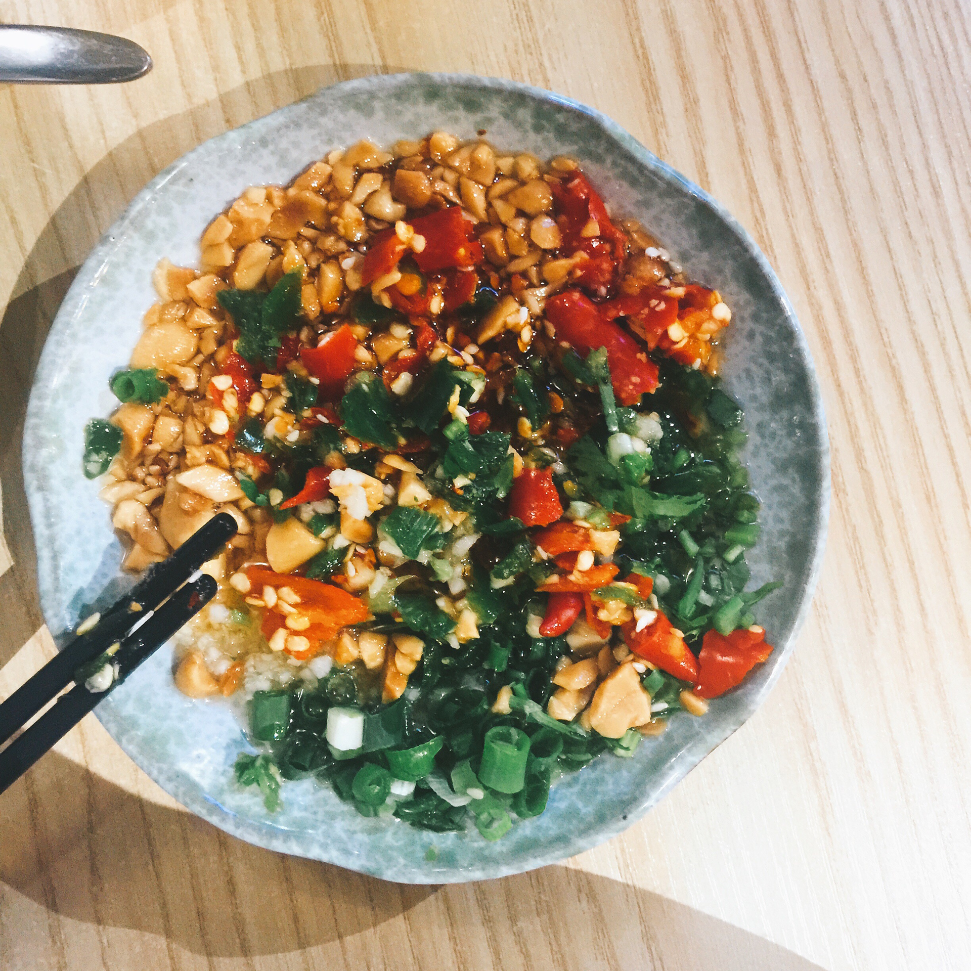 Overhead flat-lay of all ingredients for Fragrant Burmese Tea Leaf Salad with Fried Peanuts laid out on a kitchen surface.