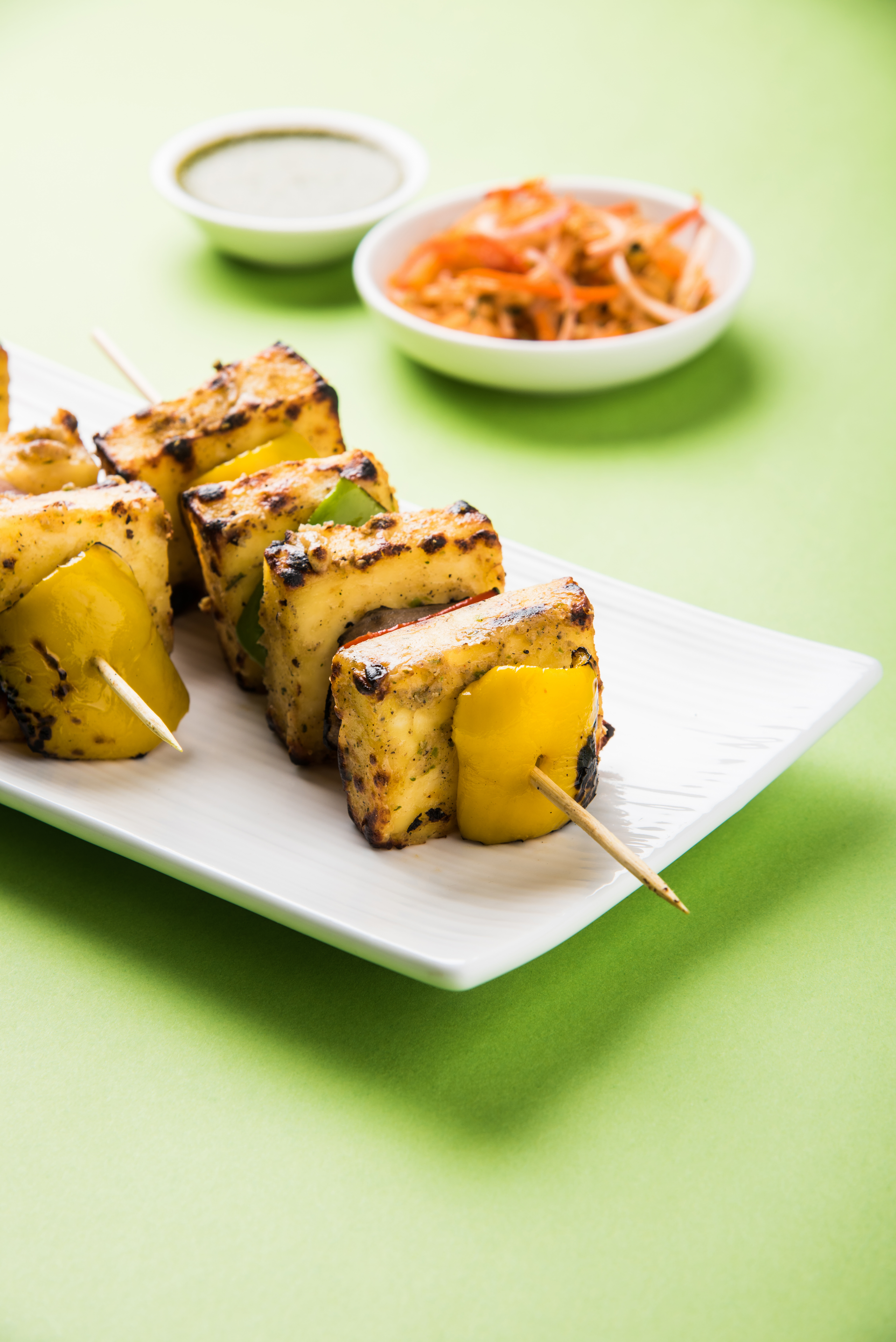 Overhead flat-lay of all ingredients for Fragrant Burmese Turmeric Tofu Skewers laid out on a kitchen surface.
