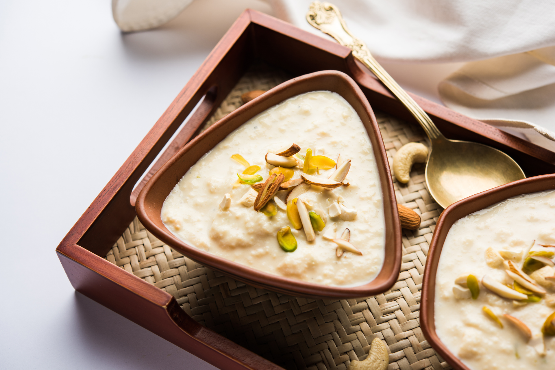 Overhead flat-lay of all ingredients for Fragrant Indian Cardamom Kheer with Saffron and Pistachios laid out on a kitchen surface.