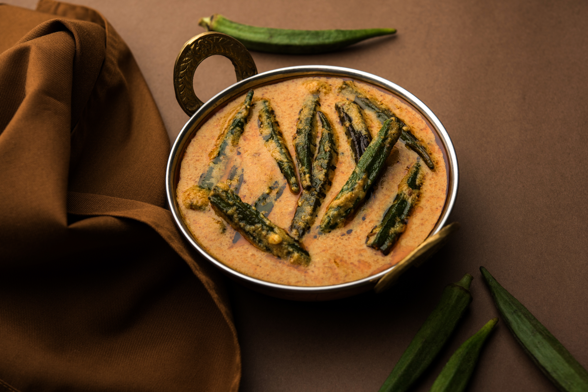 Overhead flat-lay of all ingredients for Fragrant Indian Tamarind Rasam with Curry Leaves laid out on a kitchen surface.