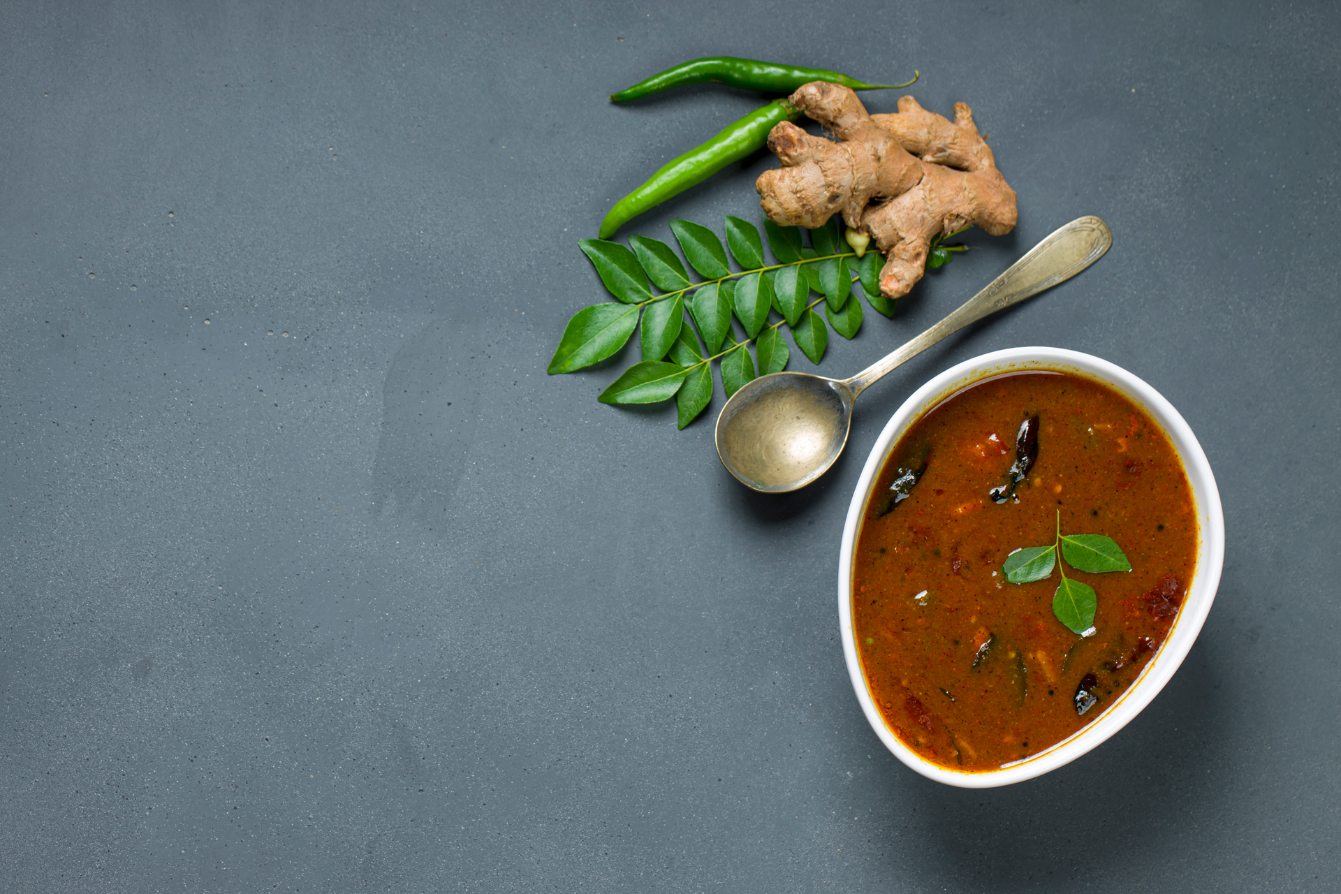 Fragrant Indian Tamarind Rasam with Curry Leaves — Soup served and photographed from above