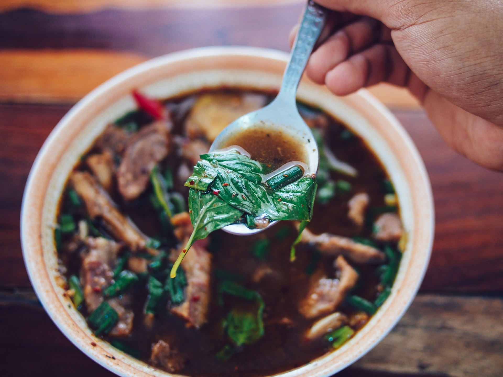Overhead flat-lay of all ingredients for Fragrant Laotian Or Lam Soup with Bitter Herbs and Beef laid out on a kitchen surface.