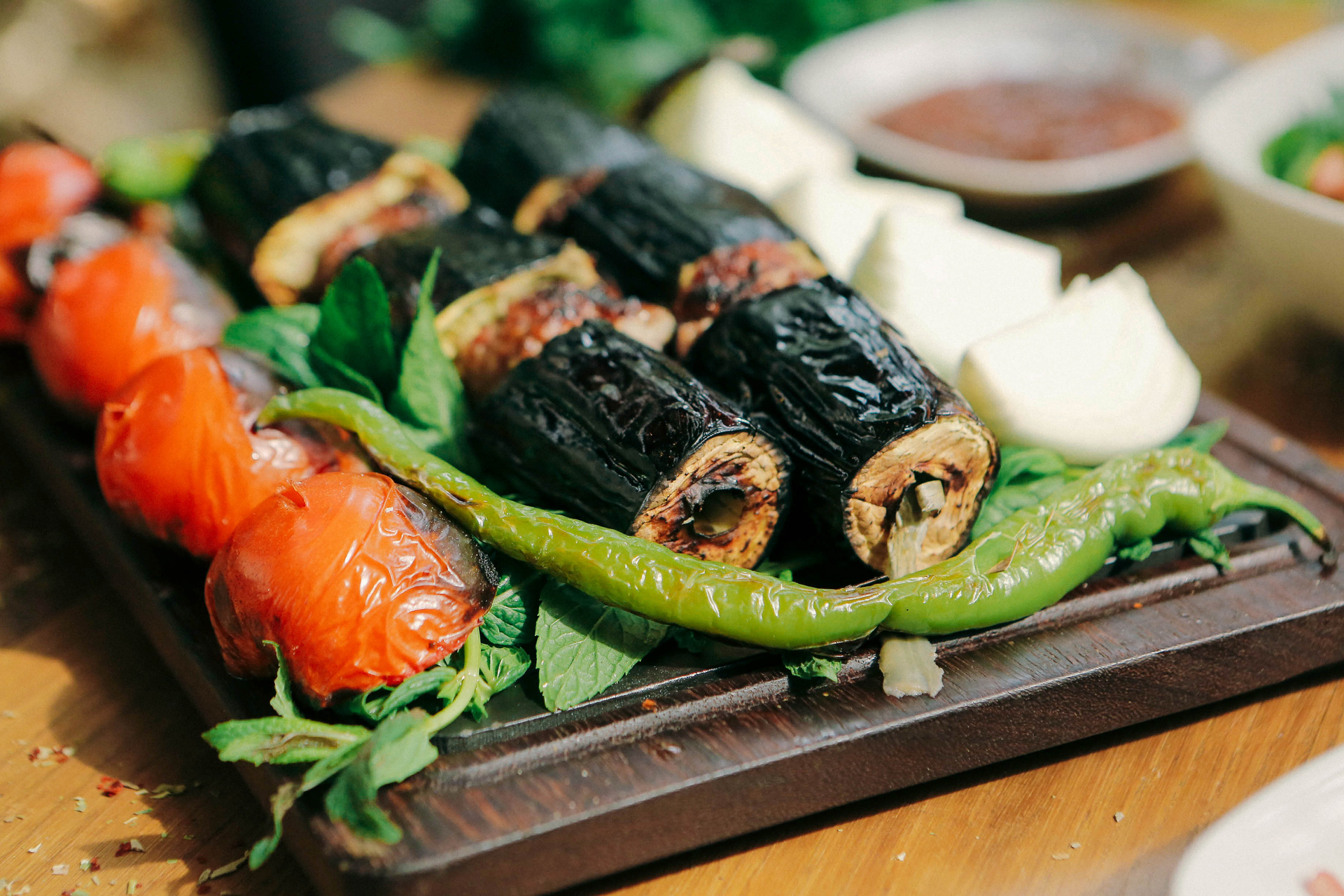 Overhead flat-lay of all ingredients for Fragrant Lebanese Sumac-Dusted Grilled Eggplant Rolls with Goat Cheese laid out on a kitchen surface.