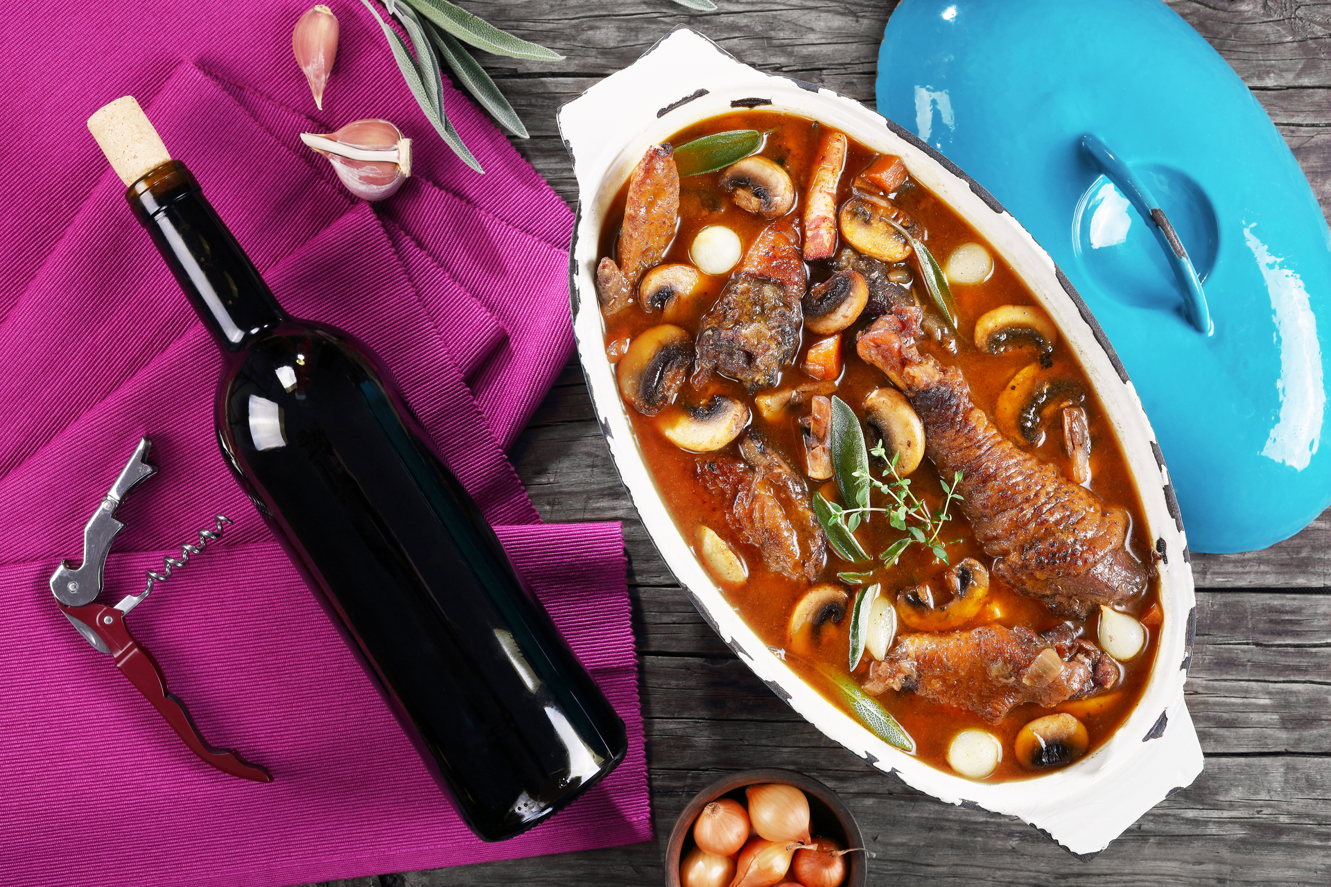 Overhead flat-lay of all ingredients for French Coq au Vin with Pearl Onions and Mushrooms laid out on a kitchen surface.