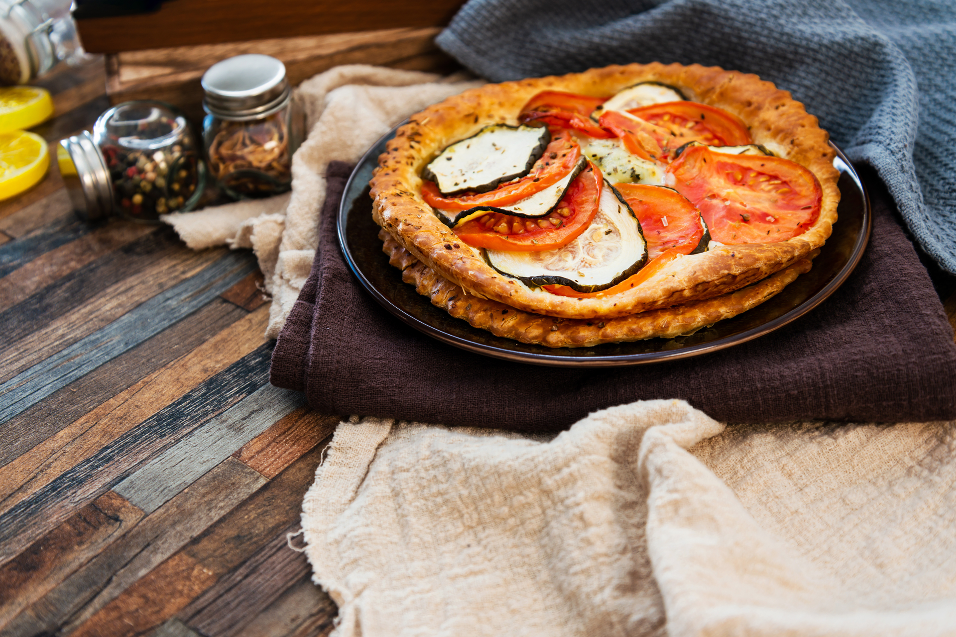 Overhead flat-lay of all ingredients for French Heirloom Tomato Tart Tatin with Lavender Honey laid out on a kitchen surface.