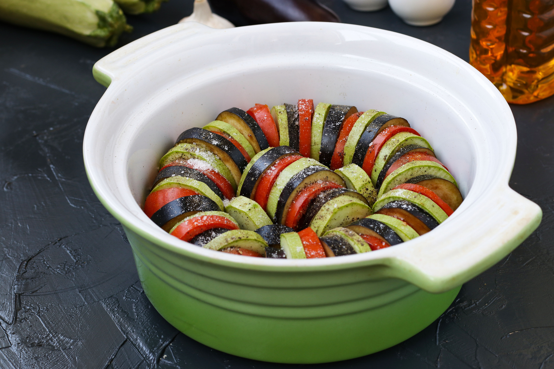 Overhead flat-lay of all ingredients for French Ratatouille with Herb-Infused Tomato Sauce laid out on a kitchen surface.