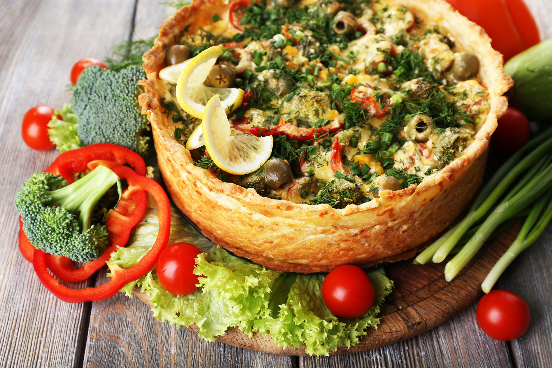 Overhead flat-lay of all ingredients for French Roasted Ratatouille Quiche with Herbes de Provence laid out on a kitchen surface.