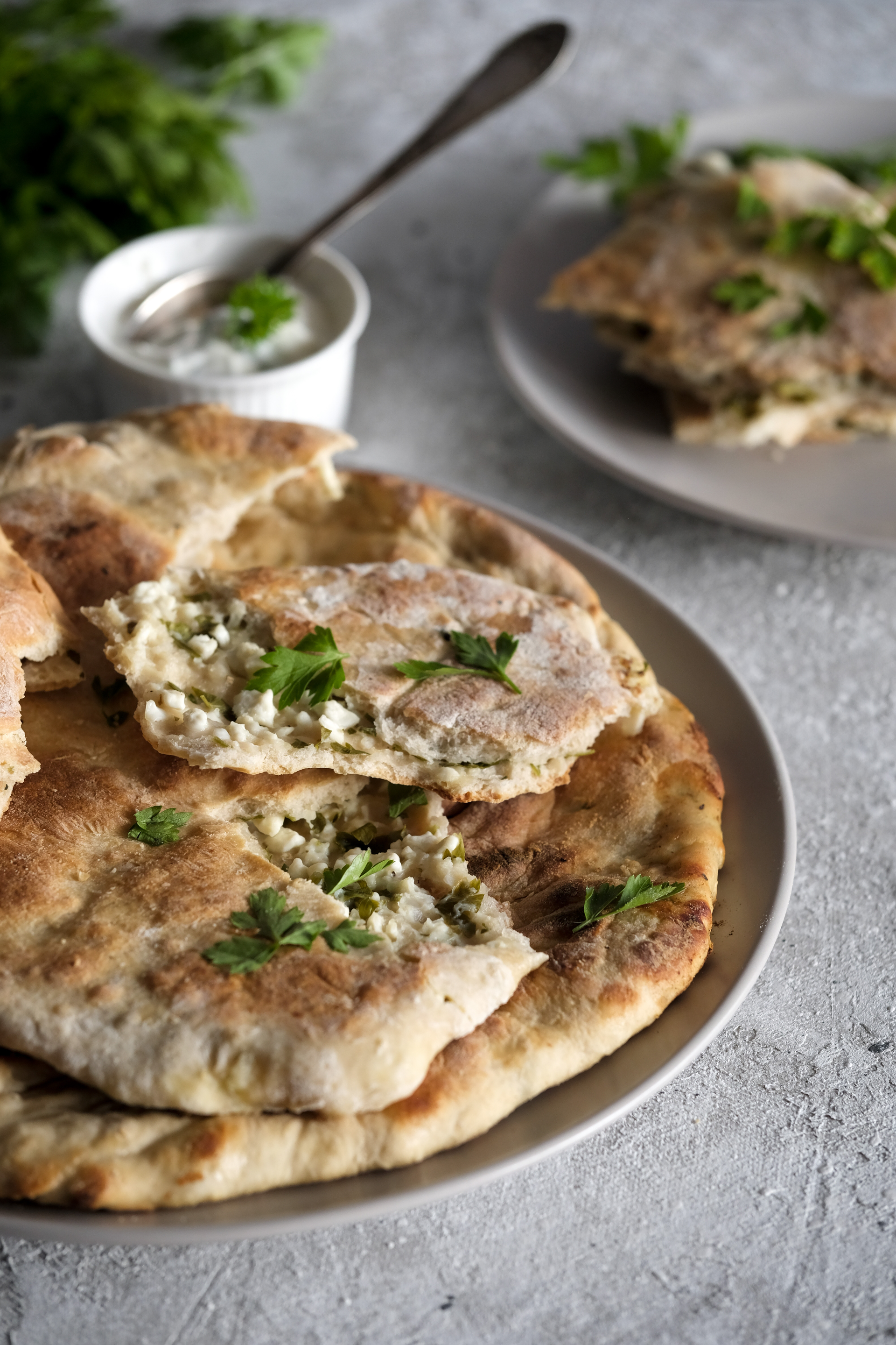 Overhead flat-lay of all ingredients for Georgian Khachapuri with Cheese and Green Onions laid out on a kitchen surface.