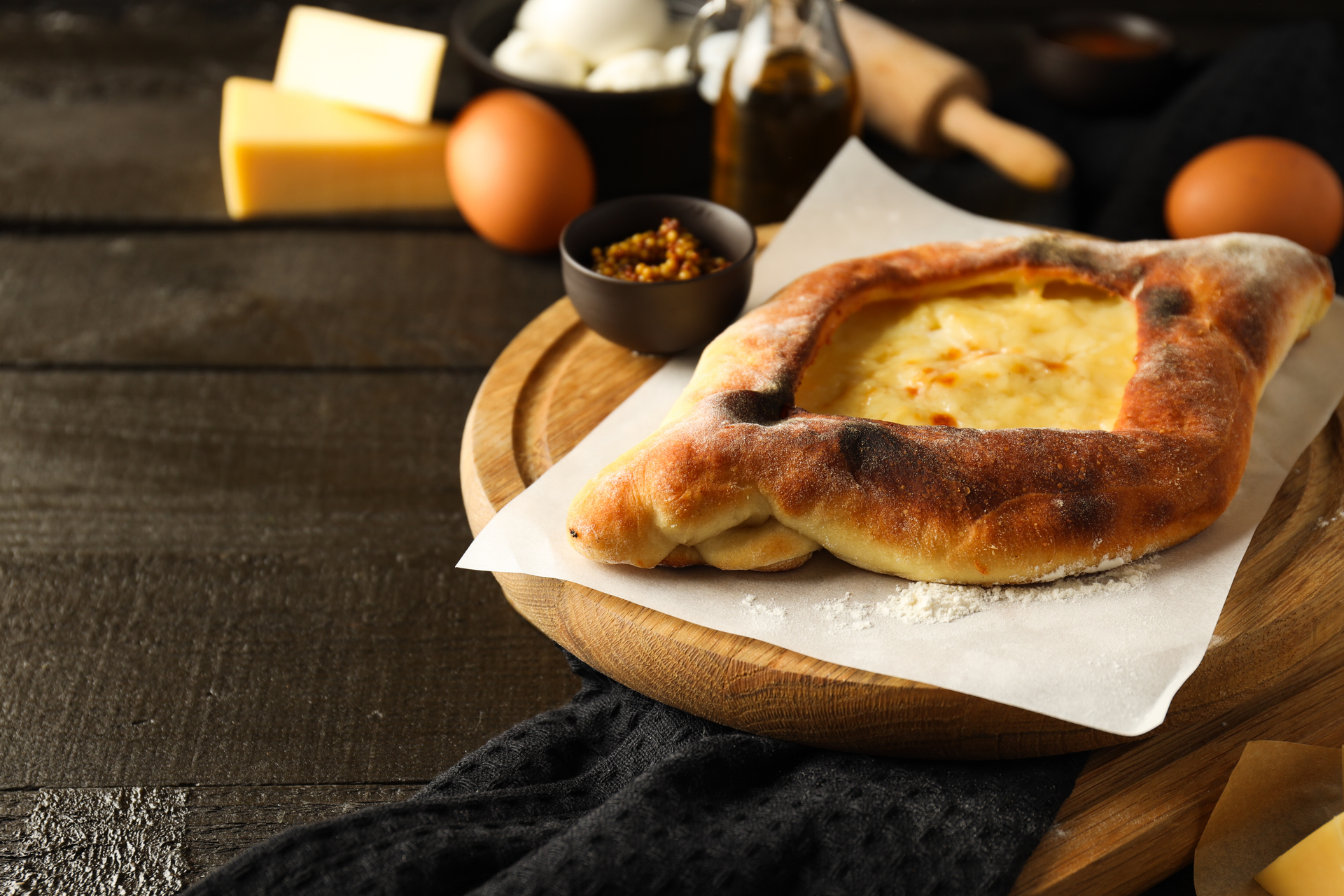 Overhead flat-lay of all ingredients for Georgian Khachapuri with Sulguni Cheese laid out on a kitchen surface.