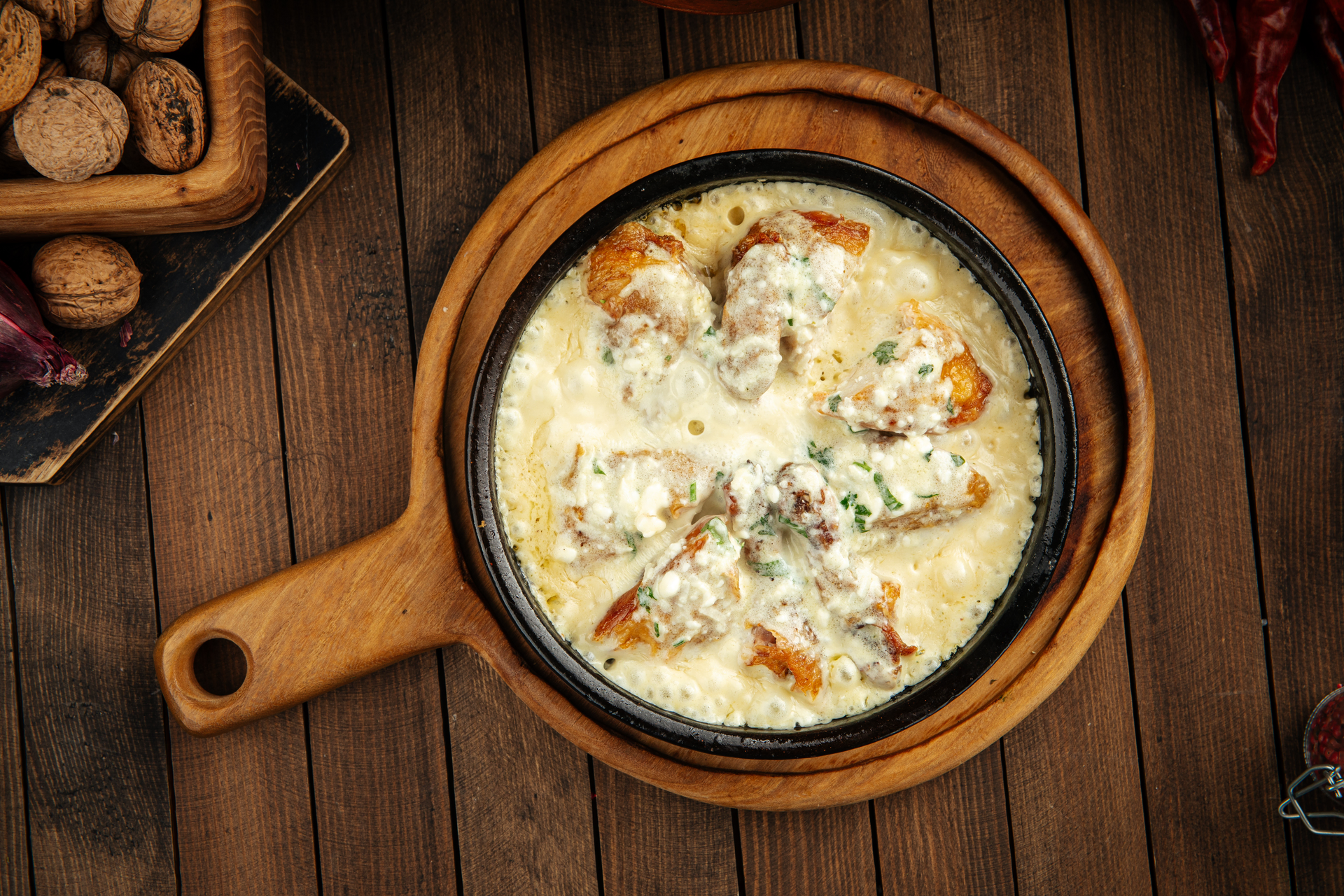 Overhead flat-lay of all ingredients for Georgian Shkmeruli with Creamy Garlic Sauce and Chicken laid out on a kitchen surface.