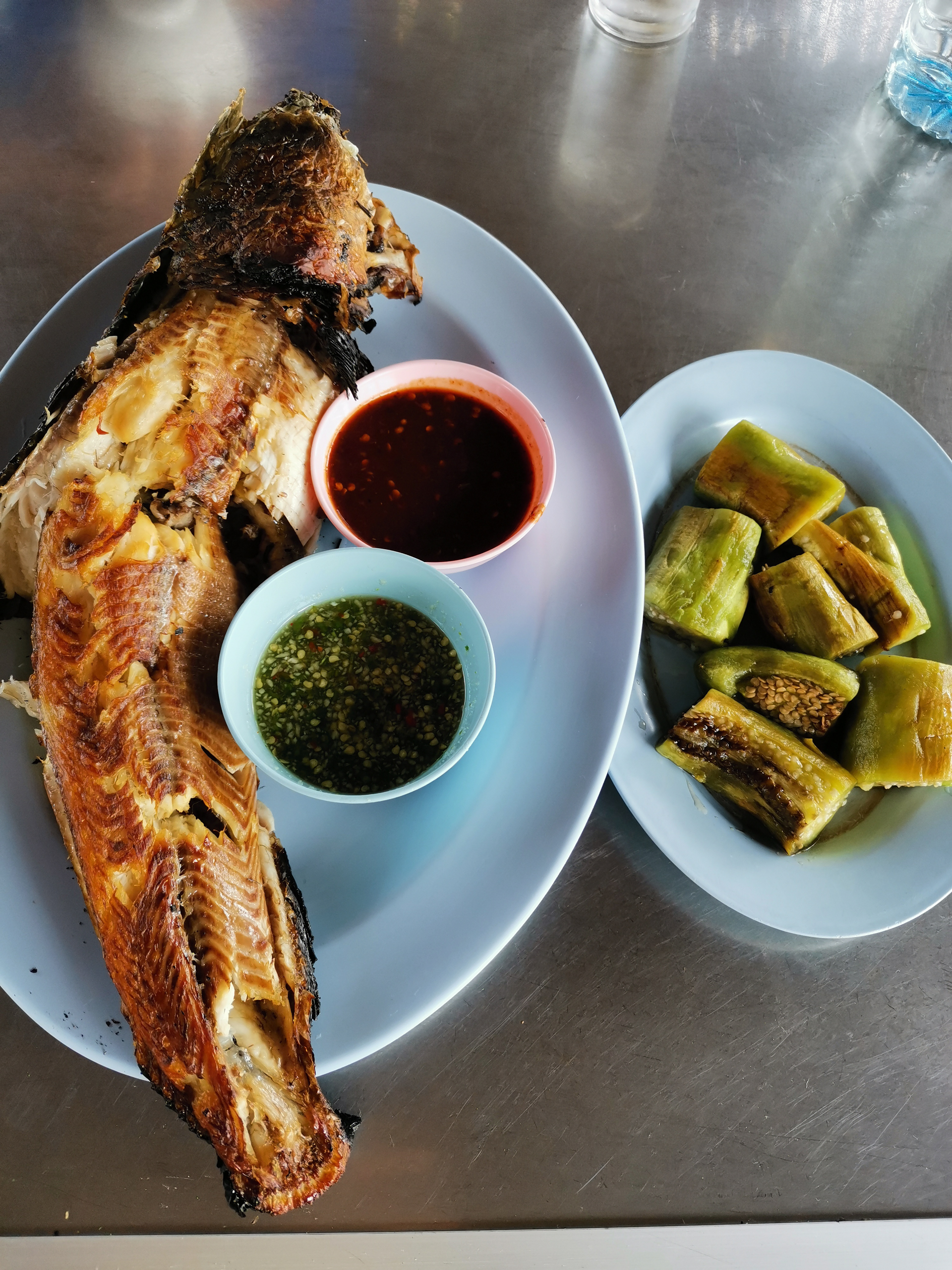 Overhead flat-lay of all ingredients for Ghanaian Grilled Tilapia with Kpakpo Shito Sauce laid out on a kitchen surface.