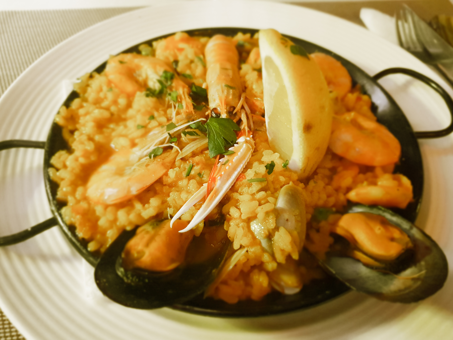 Overhead flat-lay of all ingredients for Glistening Peruvian Lobster Paella with Saffron Threads laid out on a kitchen surface.