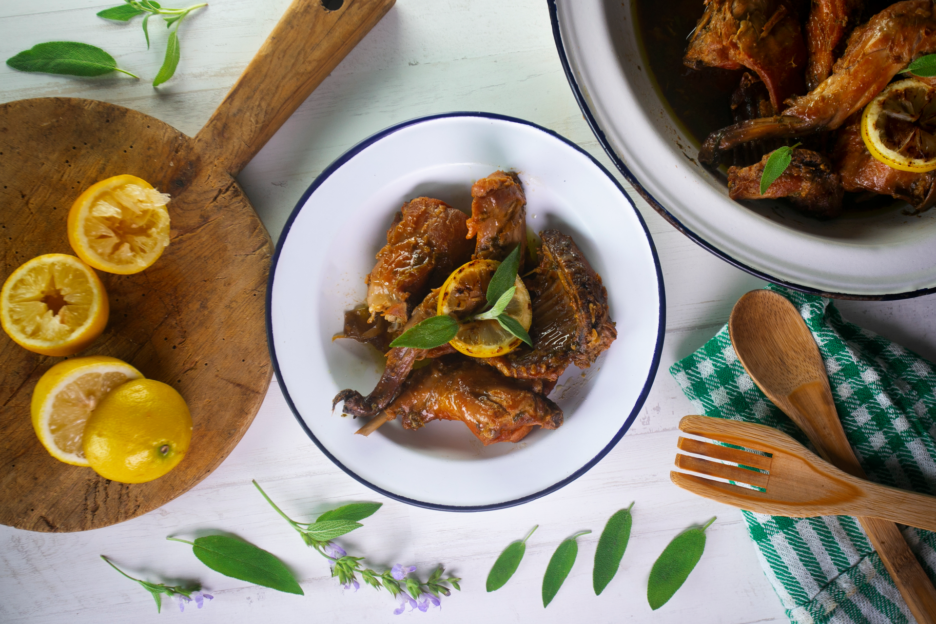Overhead flat-lay of all ingredients for Greek Lemon and Thyme Braised Rabbit laid out on a kitchen surface.