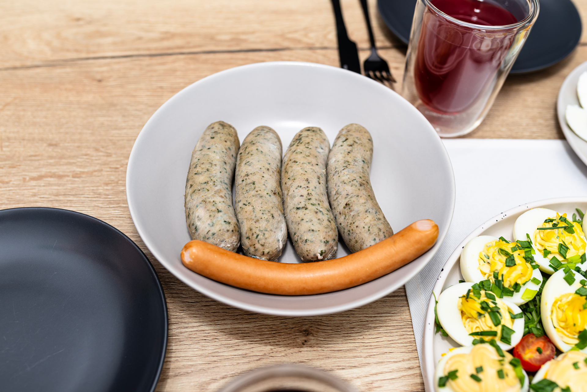 Overhead flat-lay of all ingredients for Greek Loukaniko Sausage with Lemon and Herb Dip laid out on a kitchen surface.