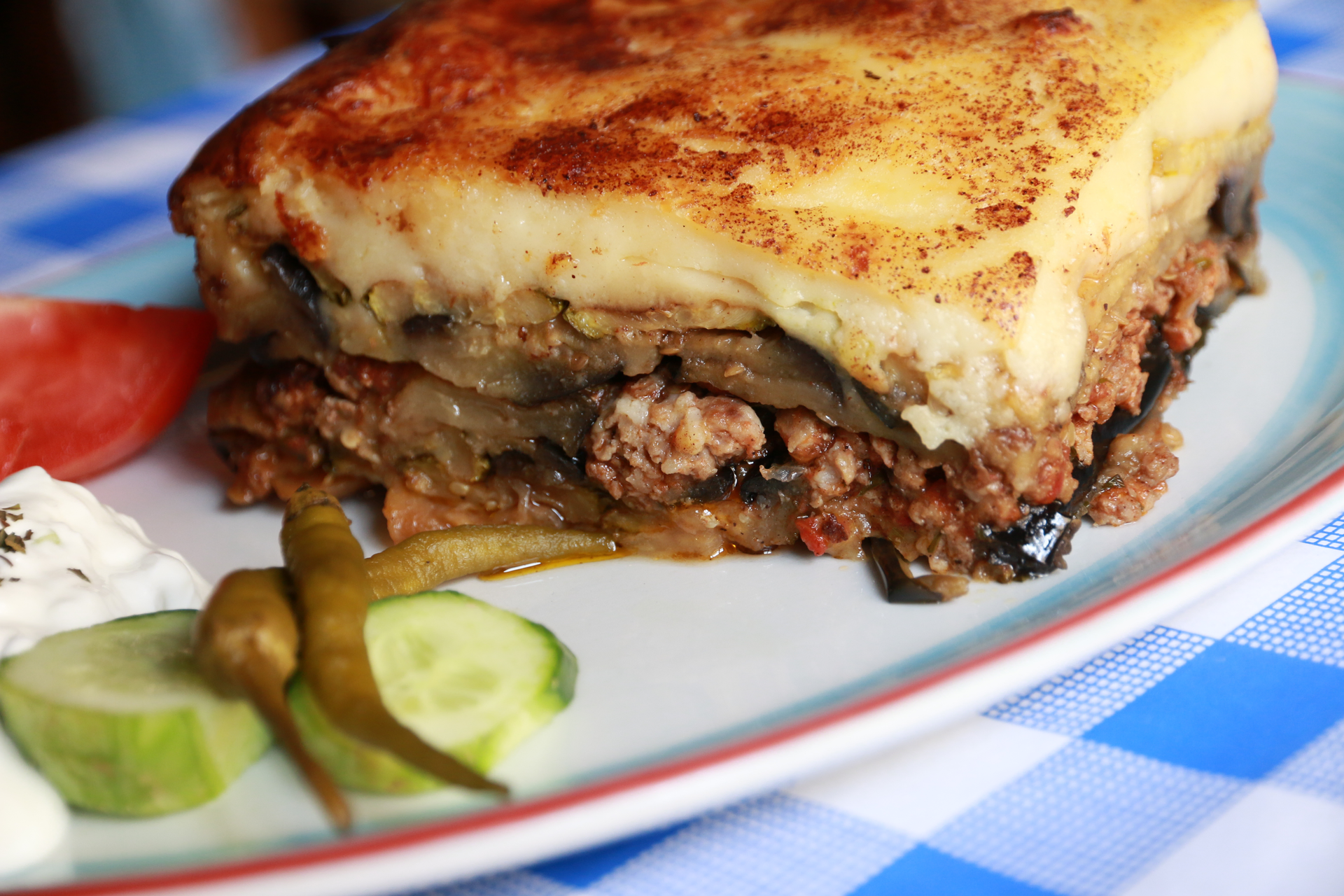 Overhead flat-lay of all ingredients for Greek Moussaka with Bechamel Sauce laid out on a kitchen surface.