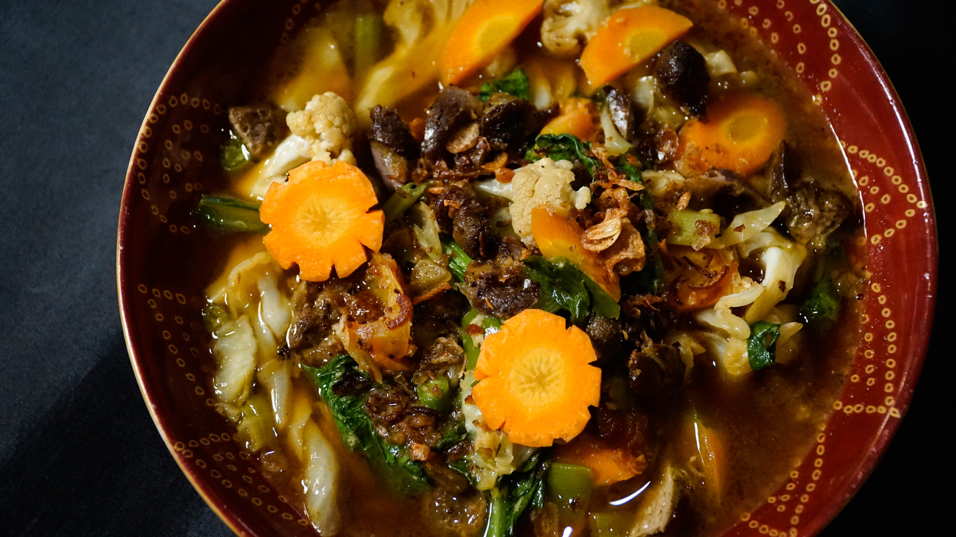 Overhead flat-lay of all ingredients for Haitian Joumou Soup with Spicy Pumpkin and Beef laid out on a kitchen surface.