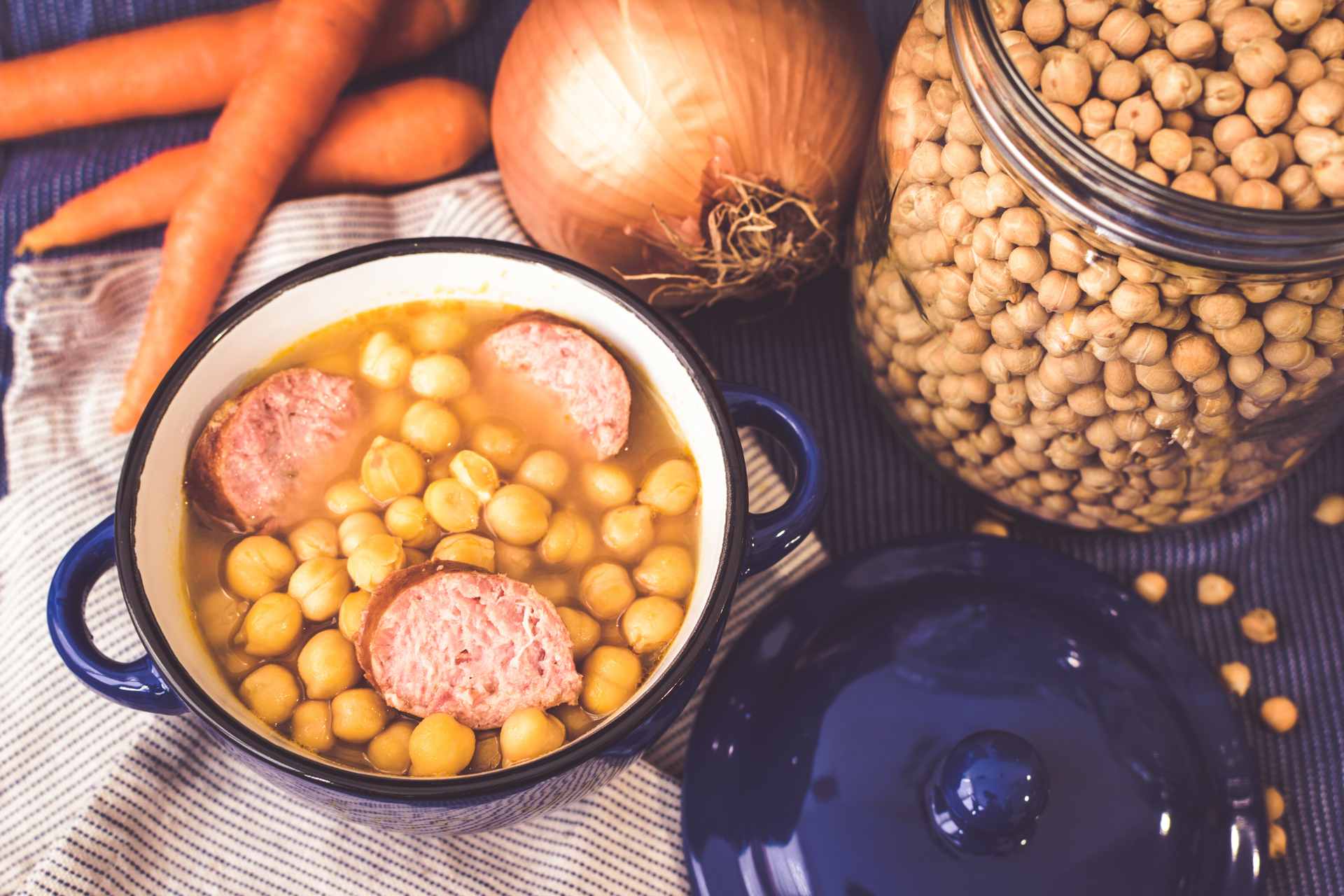 Overhead flat-lay of all ingredients for Hearty German Lentil Soup with Frankfurters and Mustard laid out on a kitchen surface.
