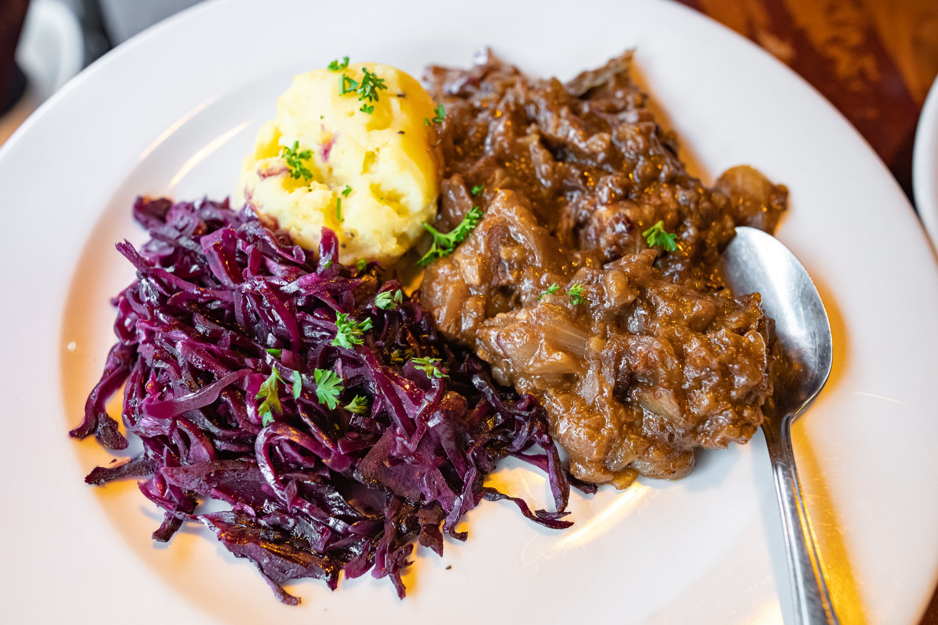 Overhead flat-lay of all ingredients for Hearty German Sauerbraten with Red Cabbage laid out on a kitchen surface.