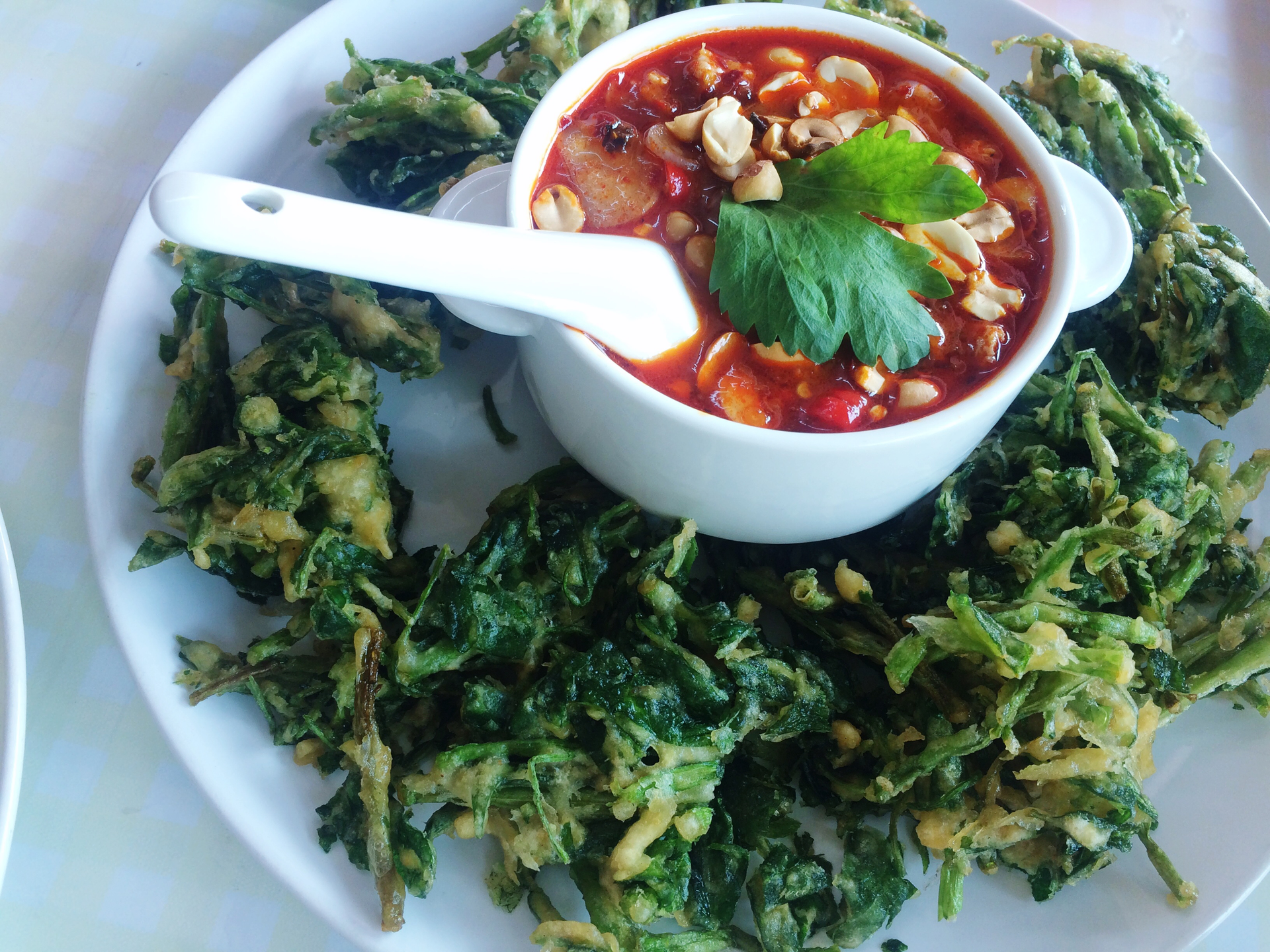 Overhead flat-lay of all ingredients for Hearty Ghanaian Peanut Soup with Ginger and Spinach laid out on a kitchen surface.