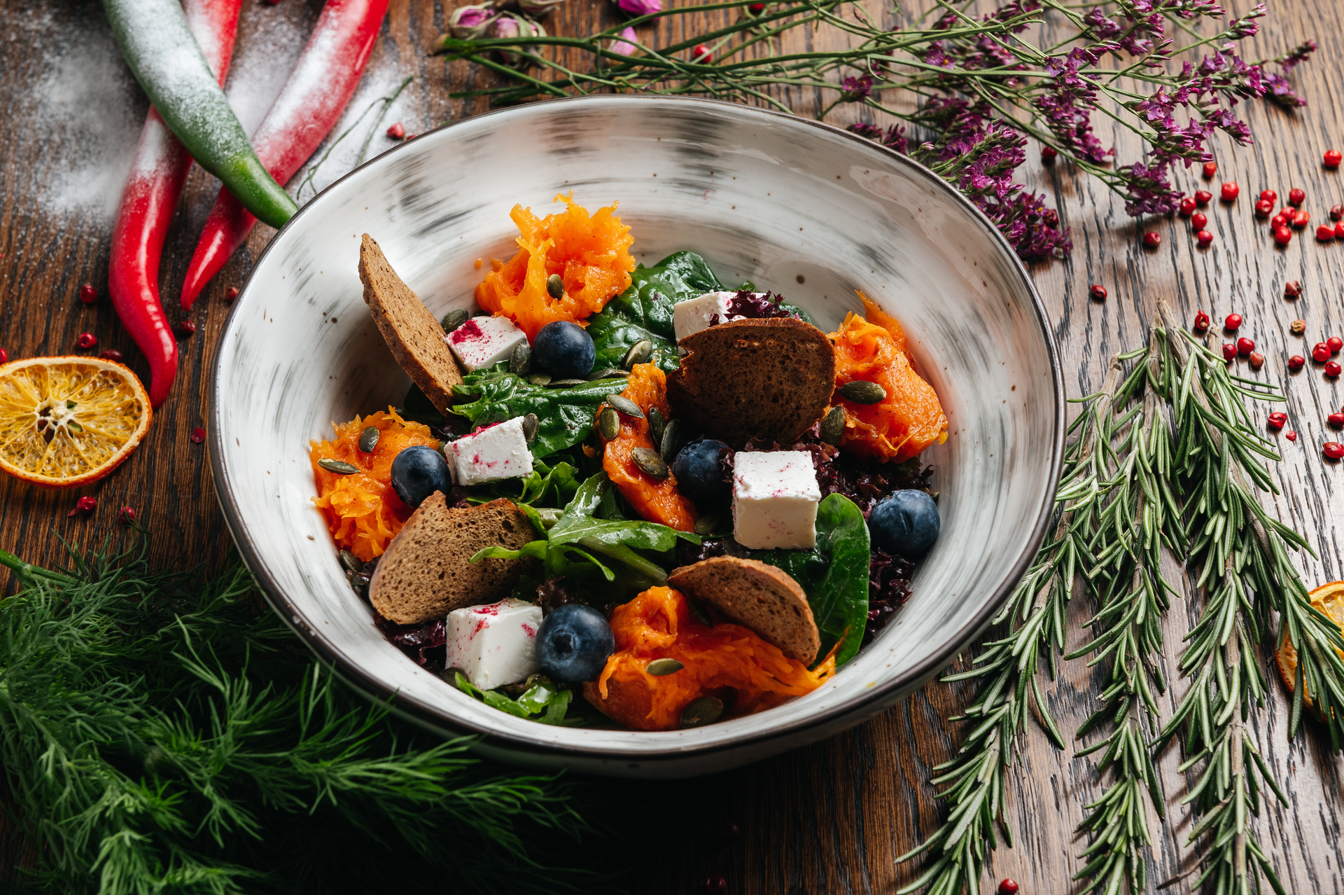 Overhead flat-lay of all ingredients for Hearty Greenlandic Muskox Stew with Arctic Herbs laid out on a kitchen surface.