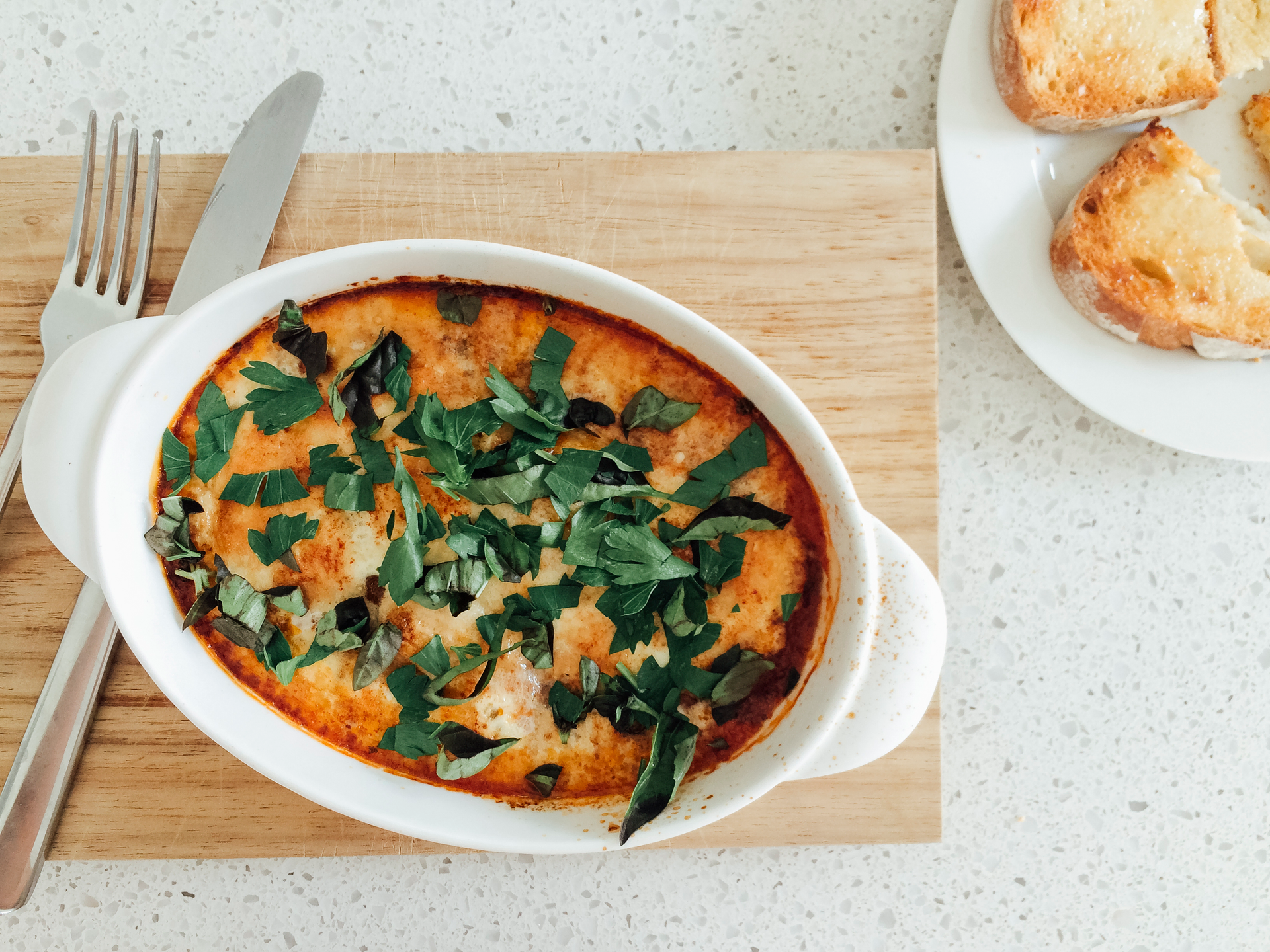 Overhead flat-lay of all ingredients for Hearty Italian Zuppa Toscana with Kale and Sausages laid out on a kitchen surface.