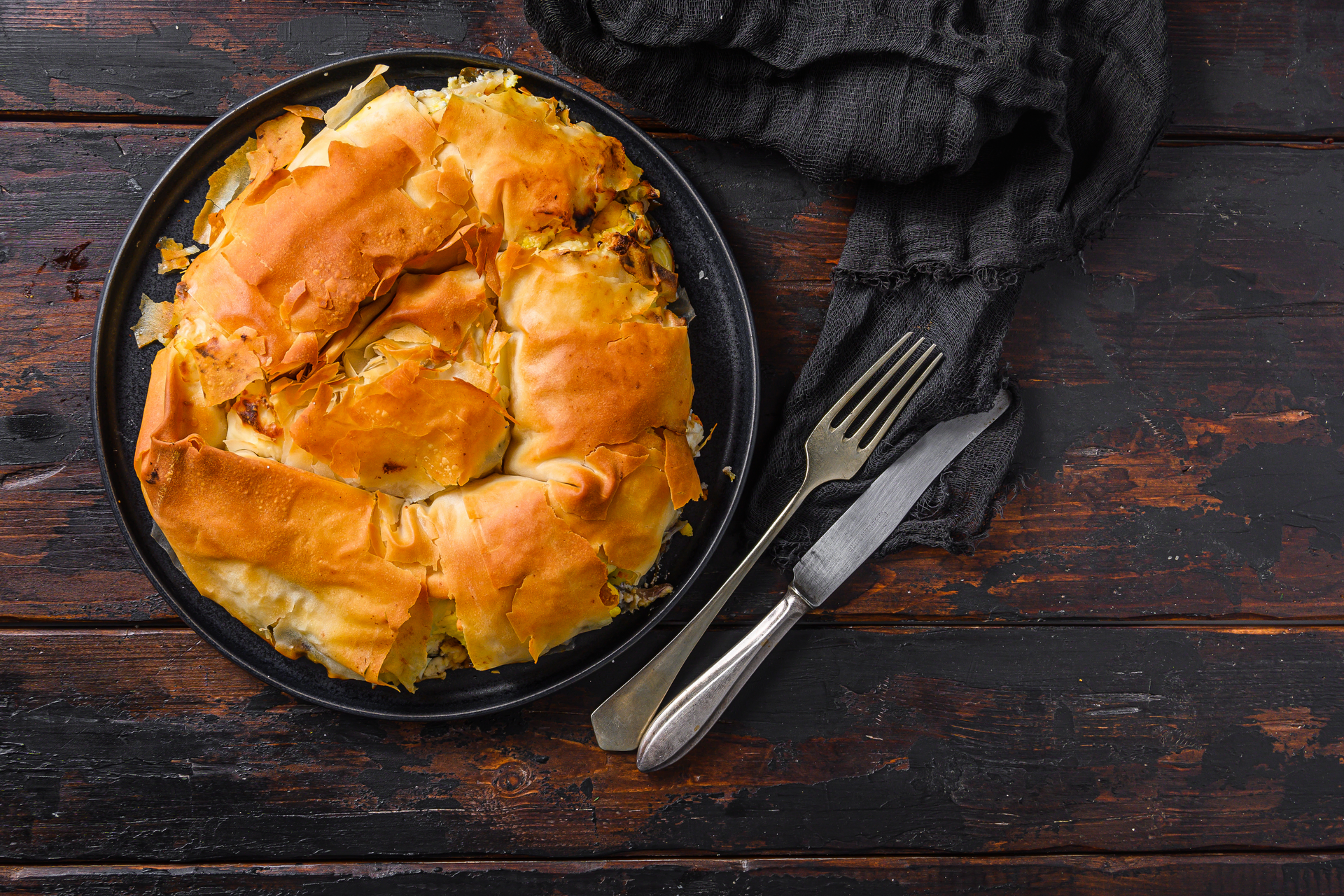 Overhead flat-lay of all ingredients for Hearty Moroccan Bastilla laid out on a kitchen surface.
