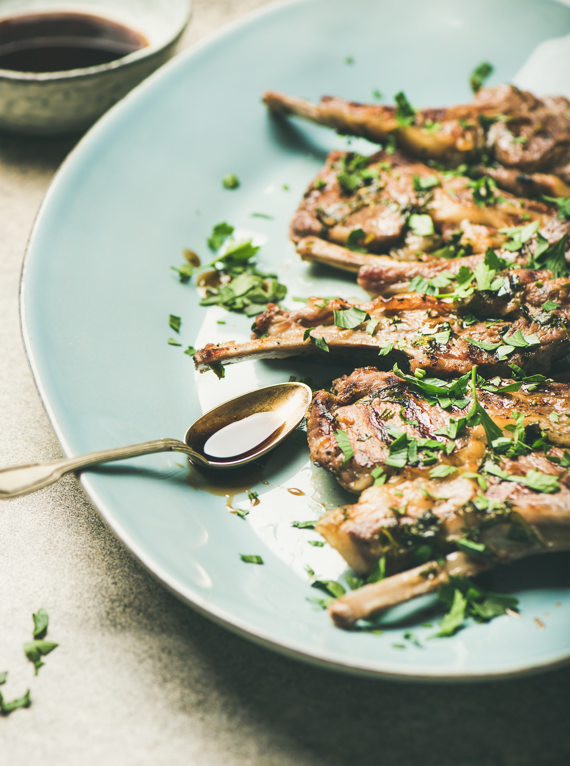 Overhead flat-lay of all ingredients for Herb-Crusted Sardinian Lamb Chops with Caper Salsa laid out on a kitchen surface.
