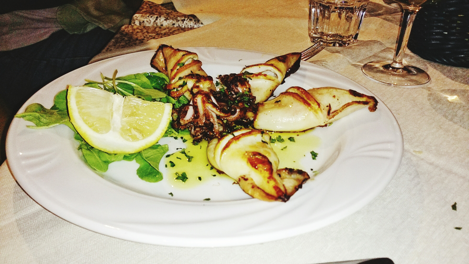Overhead flat-lay of all ingredients for Herb-Infused Tangy Greek Octopus Souvlaki with Garlic Herb Dip laid out on a kitchen surface.