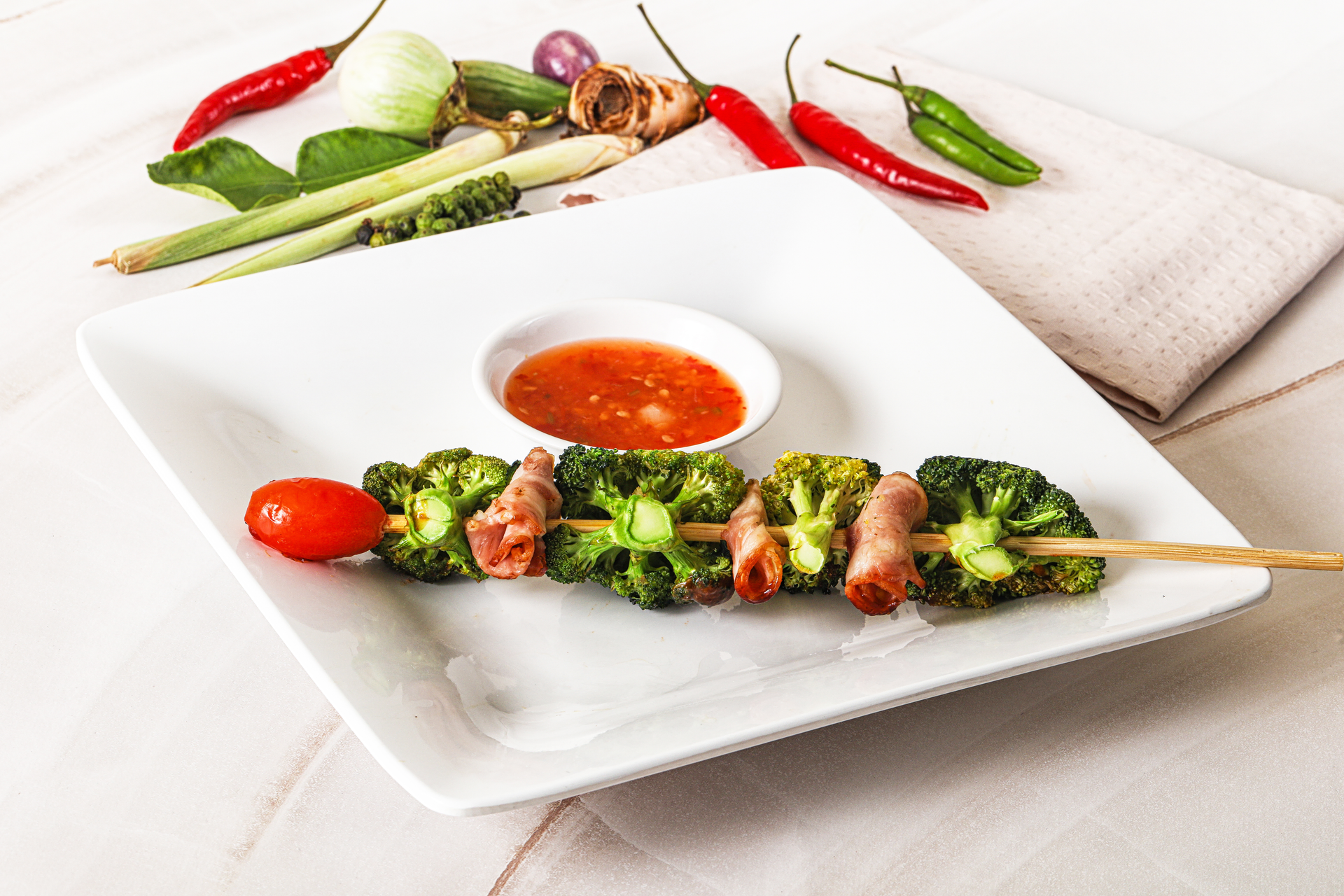 Overhead flat-lay of all ingredients for Herbal Thai Pandan Chicken Skewers with Sweet Tamarind Sauce laid out on a kitchen surface.